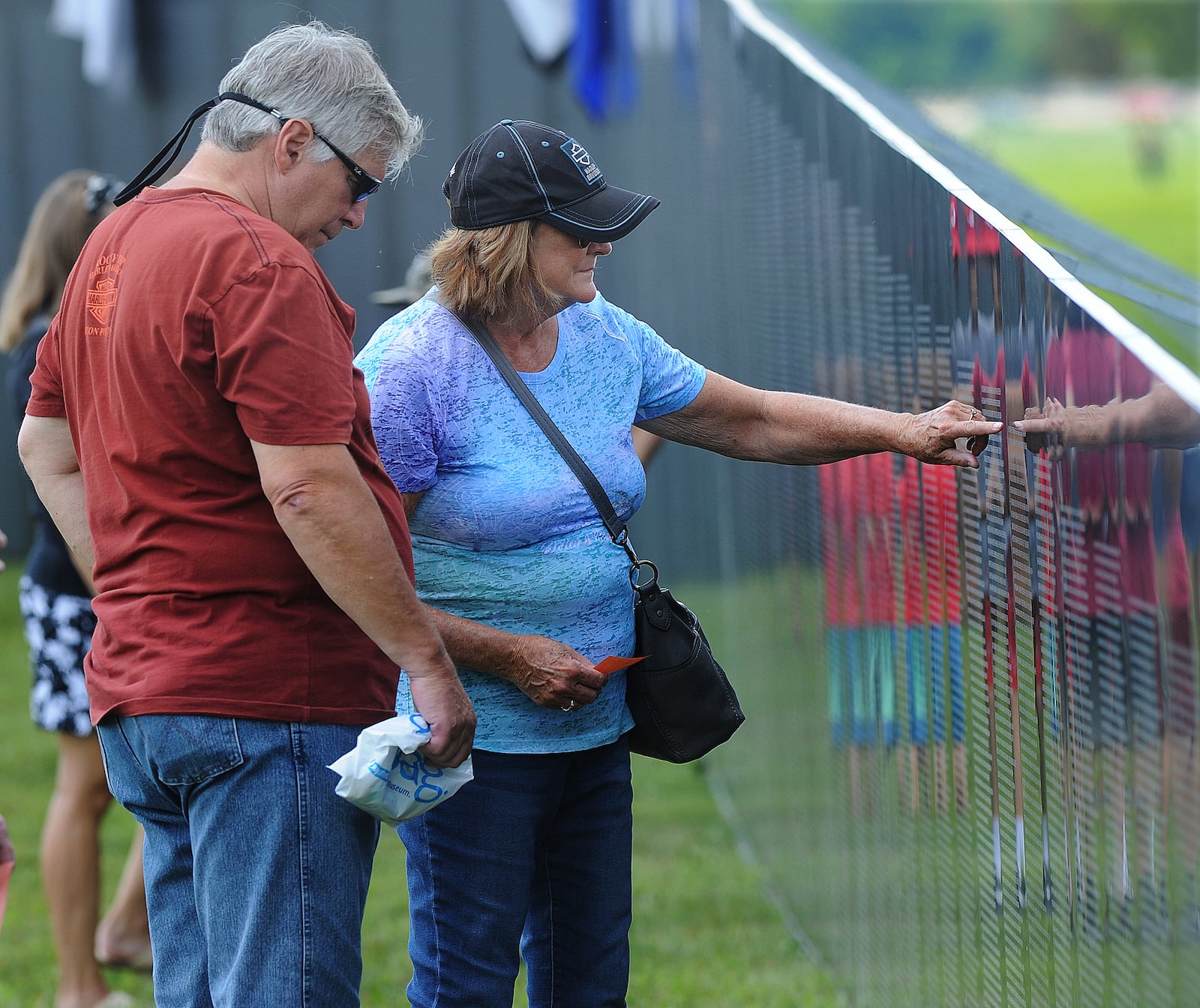 Josh and Lola Walters look names on the American Veterans Traveling Tribute Vietnam Memorial Friday Aug. 19, 2022 at the National Museum of the United States Air Force. MARSHALL GORBY / STAFF