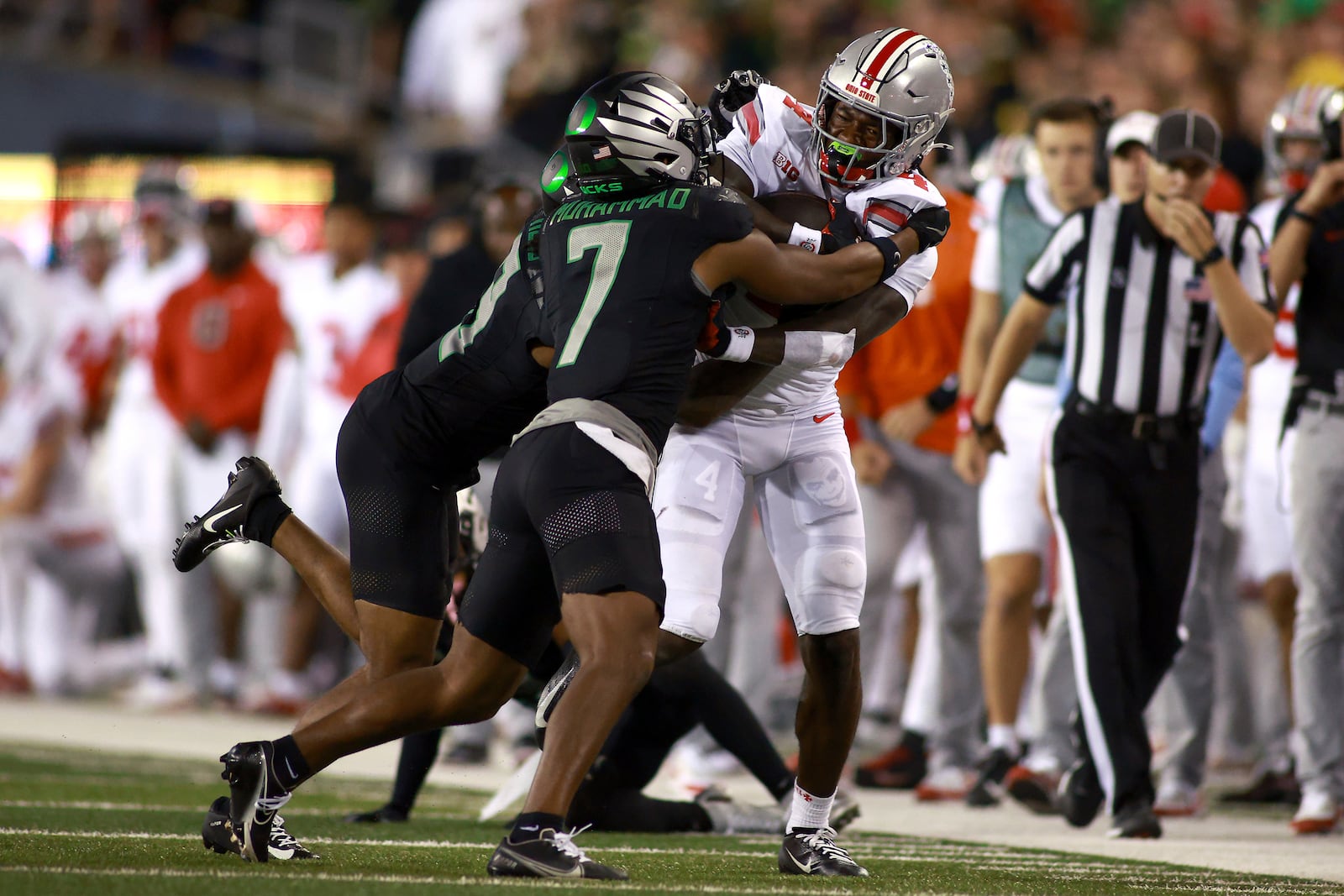 Ohio State wide receiver Jeremiah Smith (4) attempts to break a tackle by Oregon defensive back Jabbar Muhammad (7) during an NCAA college football game, Saturday, Oct. 12, 2024, in Eugene, Ore. (AP Photo/Lydia Ely)