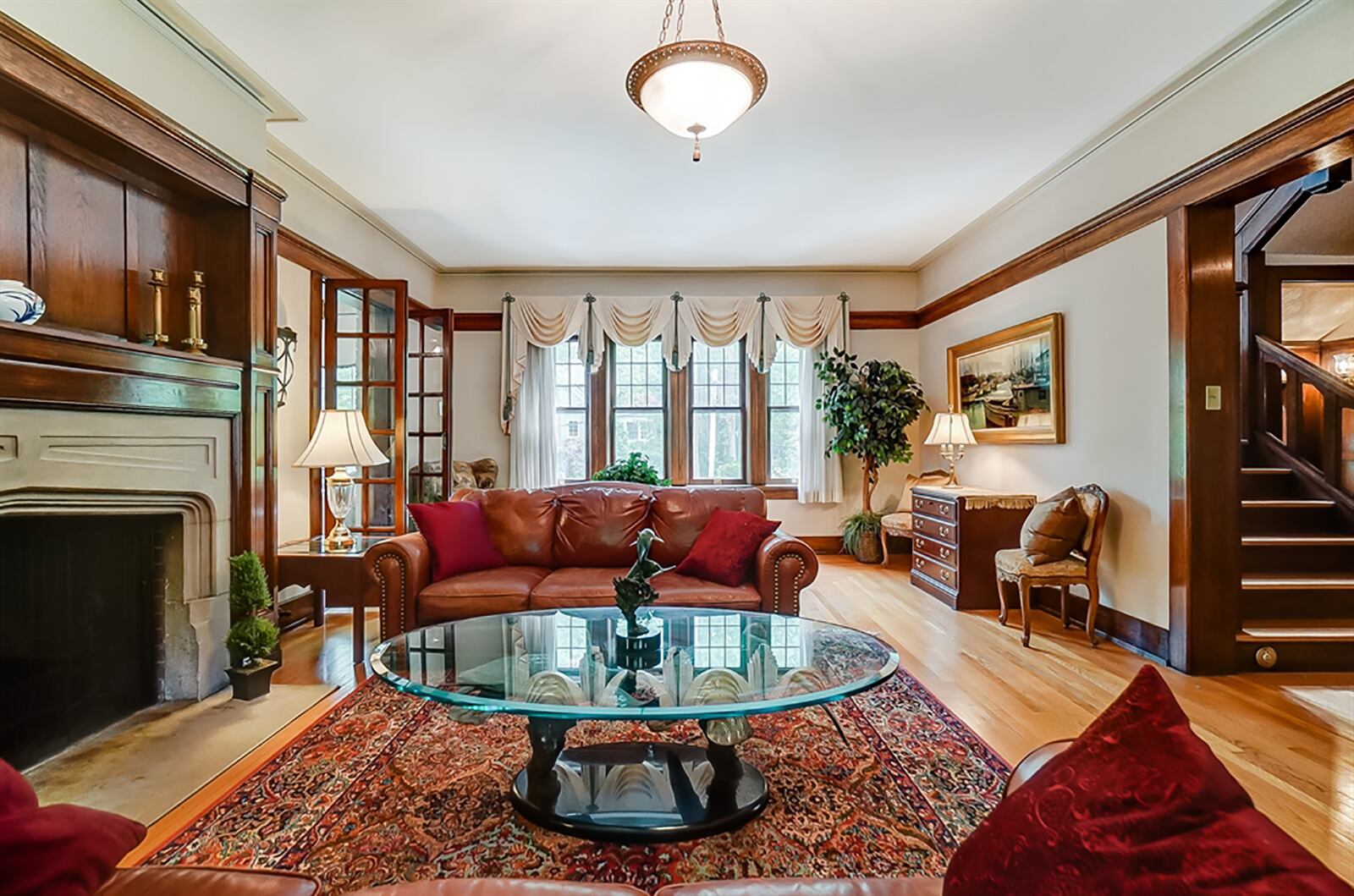 The spacious living room has a fireplace with limestone surround and hearth with crafted wood mantel. Two sets of French doors open into a sunroom, which has a wall of built-ins to allow for flexible floor plan options. CONTRIBUTED PHOTO