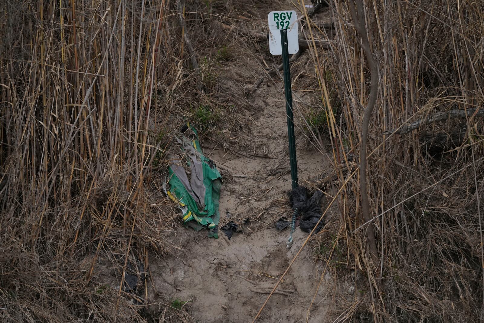 A discarded raft and other debris litter the bank at the Rio Grande Thursday, Feb. 13, 2025, in McAllen, Texas. (AP Photo/Eric Gay)