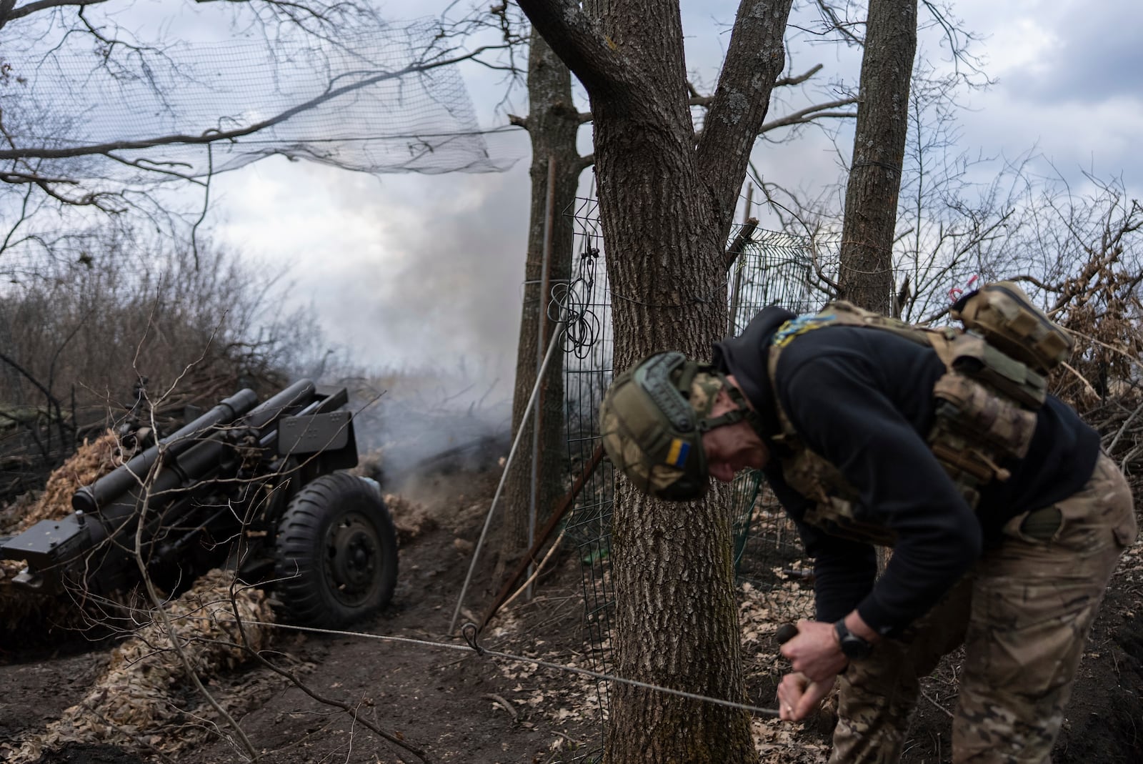 Ukrainian serviceman of Khartia brigade known by call sign "Krystal" fires M101 Howitzer towards Russian positions in Kharkiv region, Ukraine, Wednesday, March 12, 2025. (AP Photo/Alex Babenko)