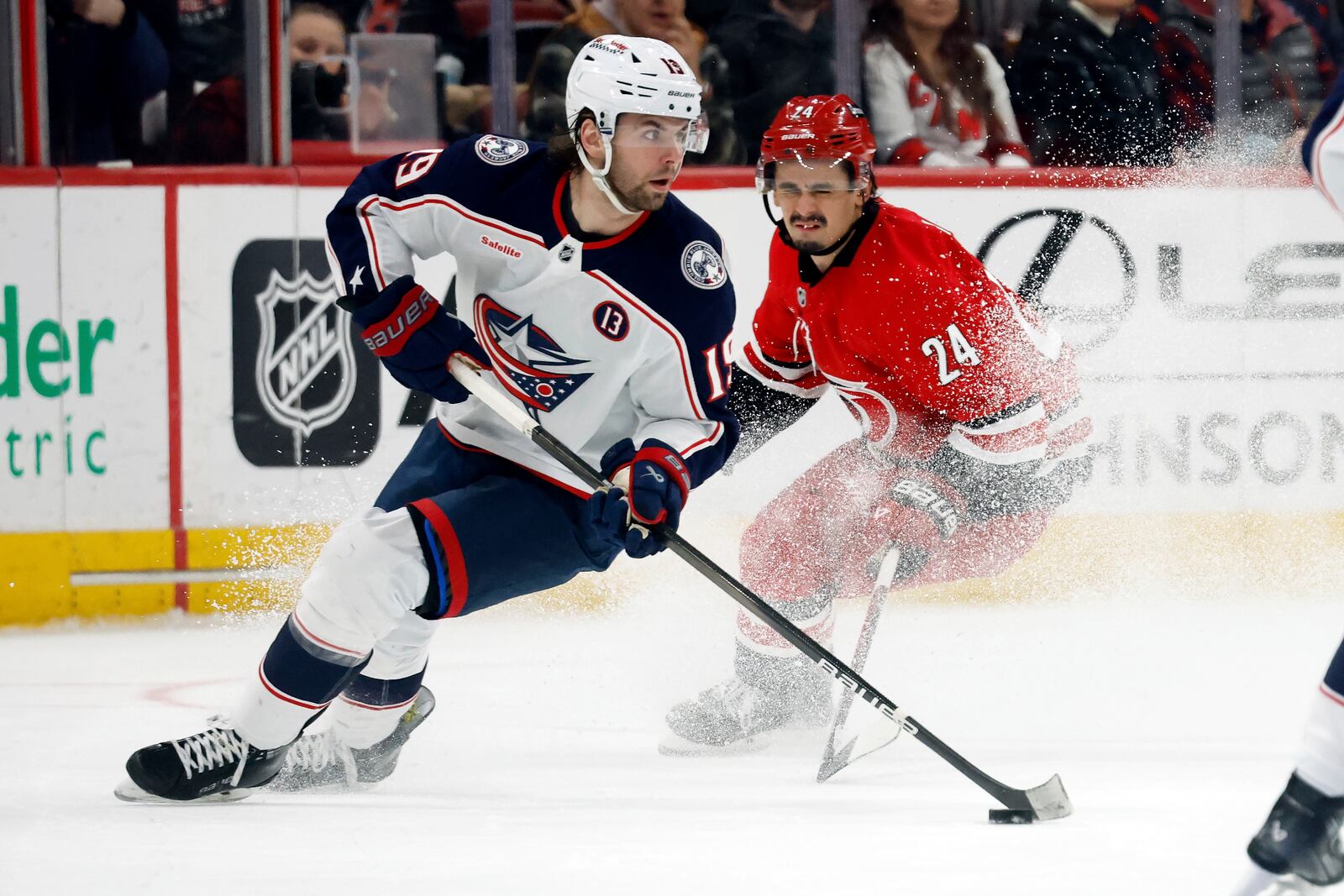 Columbus Blue Jackets' Adam Fantilli (19) controls the puck in front of Carolina Hurricanes' Seth Jarvis (24) during the second period of an NHL hockey game in Raleigh, N.C., Thursday, Jan. 23, 2025. (AP Photo/Karl DeBlaker)