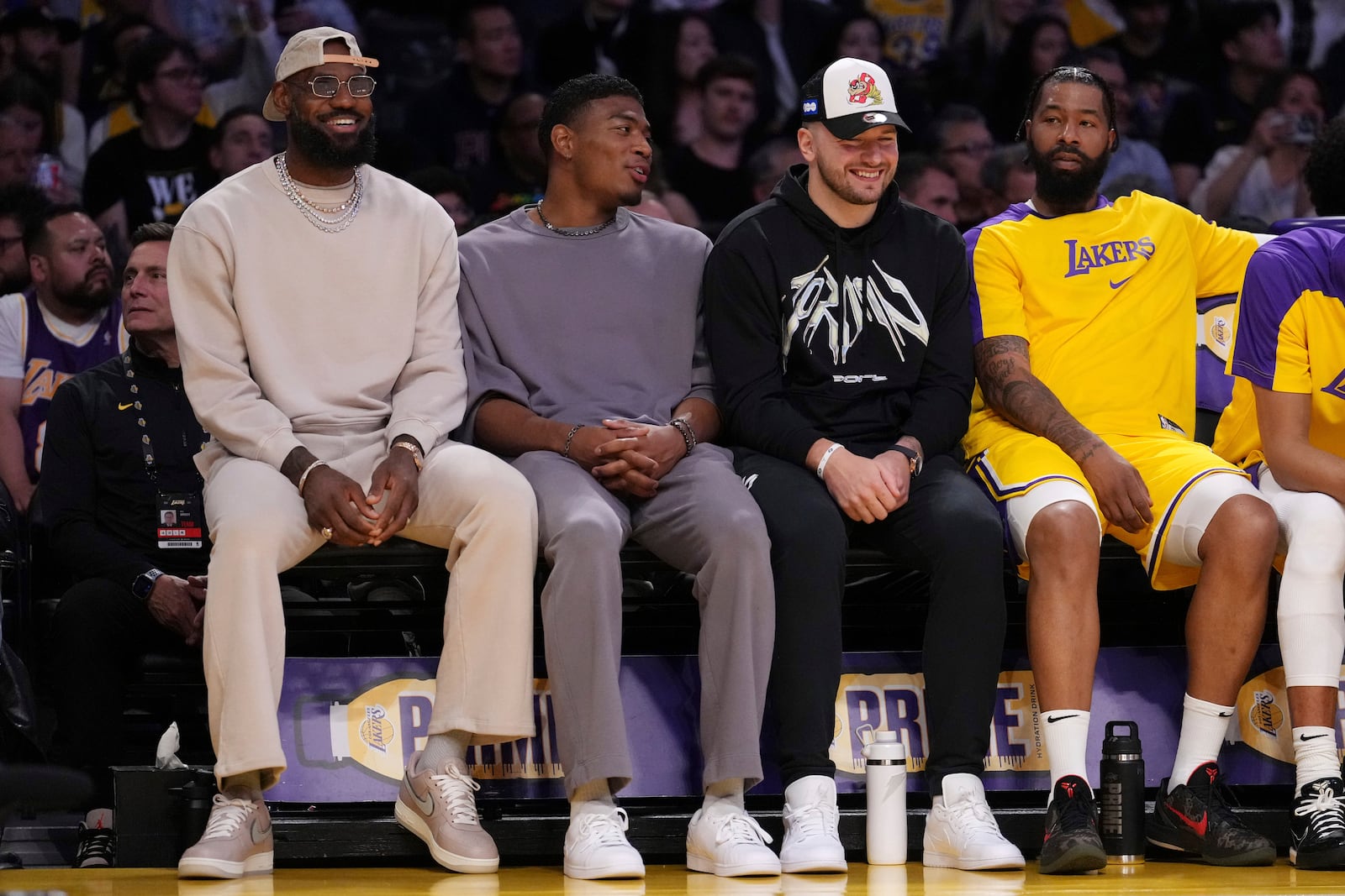 Los Angeles Lakers forward LeBron James, left, forward Rui Hachimura, second from left, guard Luka Doncic, second from right, and forward Markieff Morris sit on the bench during the first half of an NBA basketball game against the Milwaukee Bucks Thursday, March 20, 2025, in Los Angeles. (AP Photo/Mark J. Terrill)