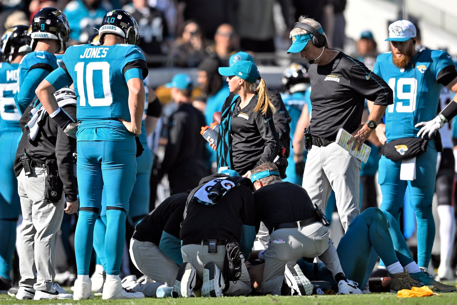 Jacksonville Jaguars head coach Doug Pederson, second from right, looks on a trainers attend to quarterback Trevor Lawrence after a late hit by Houston Texans linebacker Azeez Al-Shaair during the first half of an NFL football game Sunday, Dec. 1, 2024, in Jacksonville, Fla. (AP Photo/Phelan M. Ebenhack)