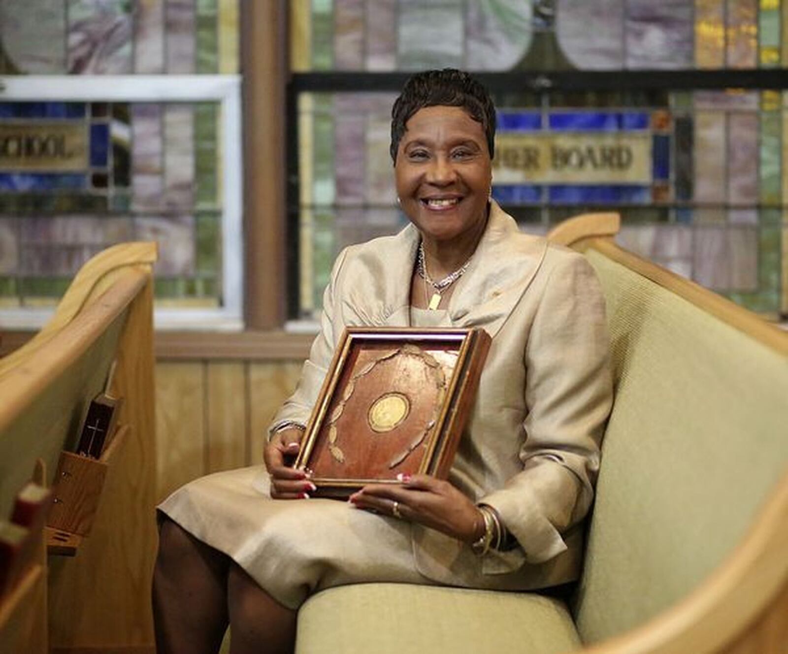 Longtime Dayton Public Schools administrator Lucinda Williams Adams and the gold medal she won in the 1960 Olympics. DAMON HIGGINS/PALM BEACH POST