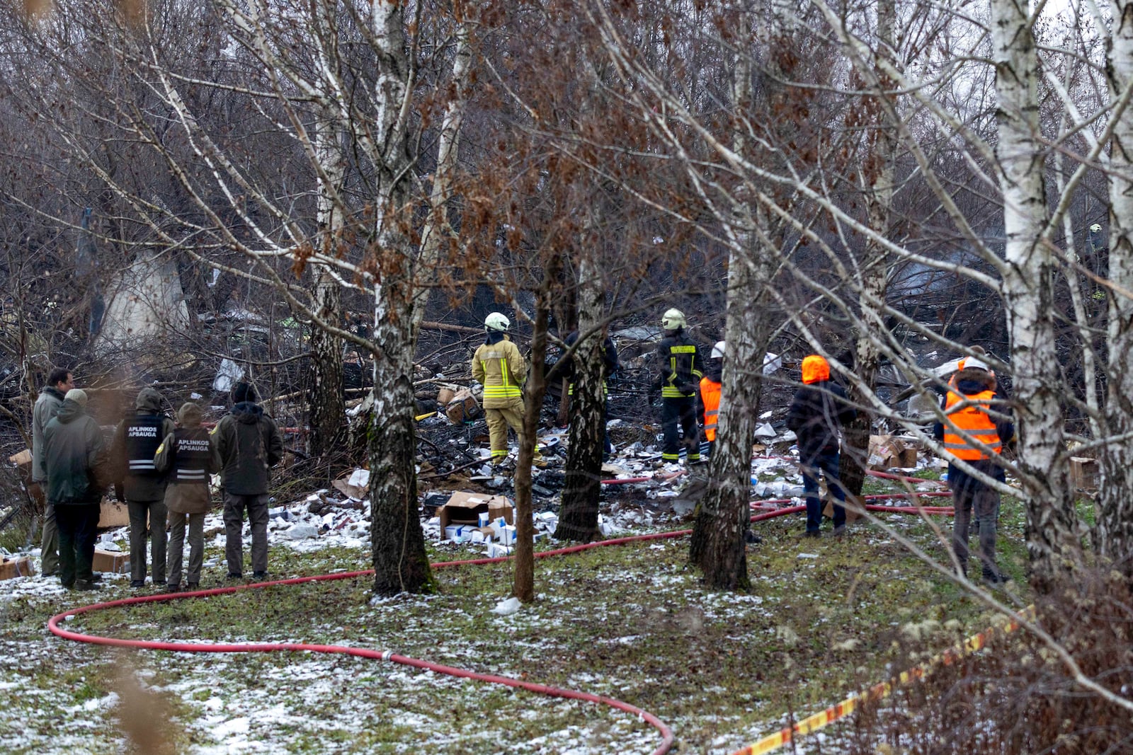 Lithuanian Emergency Ministry employees work near the place where a DHL cargo plane crashed into a house near the Lithuanian capital Vilnius, Lithuania, Lithuania, Monday, Nov. 25, 2024. (AP Photo/Mindaugas Kulbis)