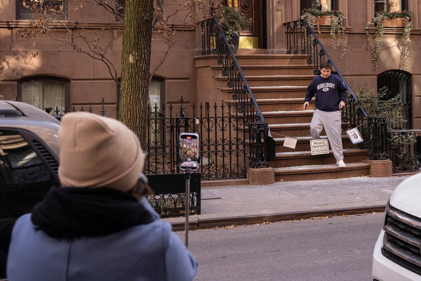 A resident steps over a chain restricting access to the brownstone where Carrie Bradshaw lived in “Sex and the City”, in New York, Wednesday, Jan. 15, 2025. The city’s Landmarks Preservation Commission approved an application for a metal gate for the front staircase of the Manhattan brownstone to keep away tourists who endlessly trespass and pose for pictures. (AP Photo/Yuki Iwamura)