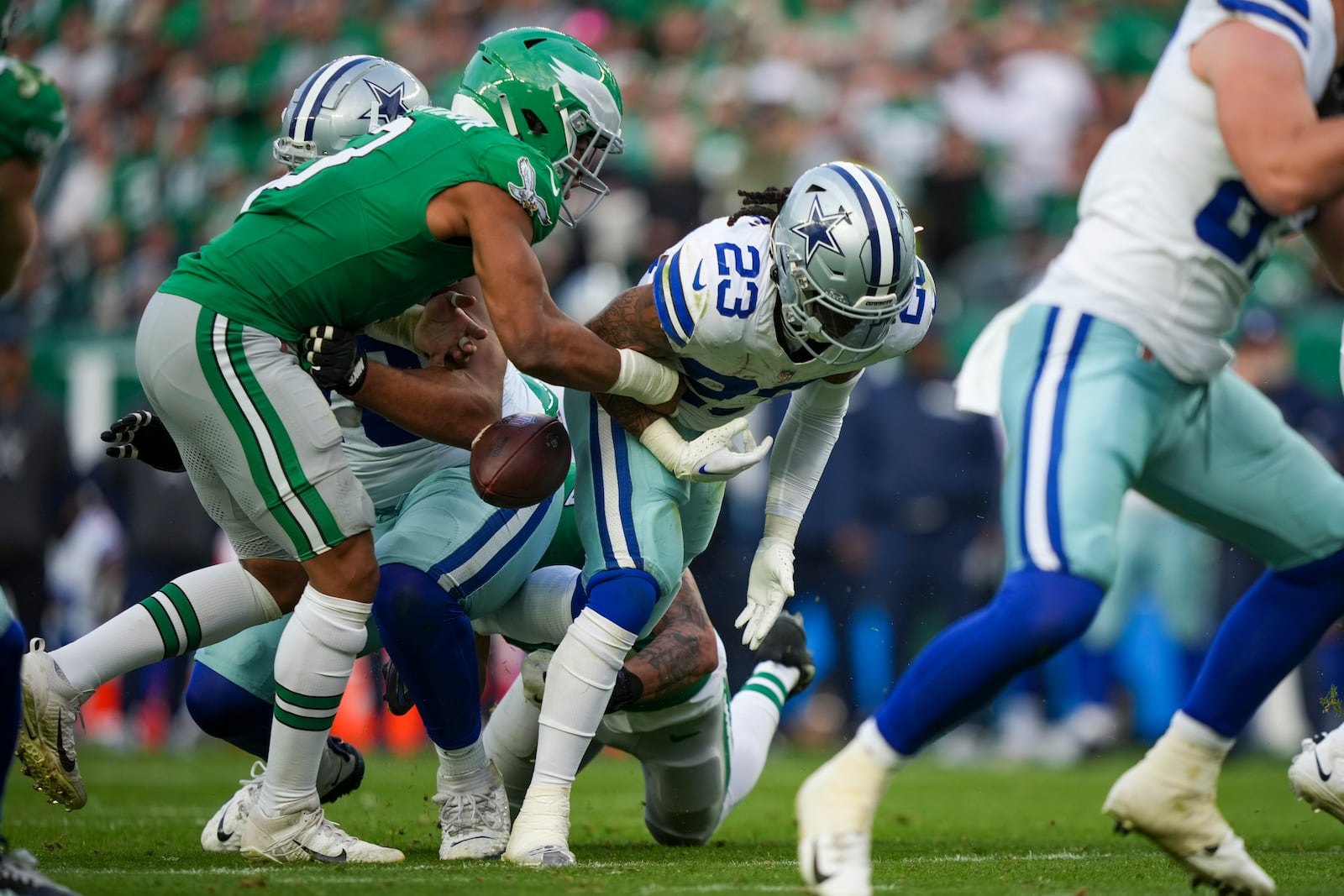 Philadelphia Eagles linebacker Nolan Smith Jr., left, punches the ball out of the hands of Dallas Cowboys running back Rico Dowdle (23) during the second half of an NFL football game, Sunday, Dec. 29, 2024, in Philadelphia. The Eagles recovered the fumble. (AP Photo/Matt Slocum)