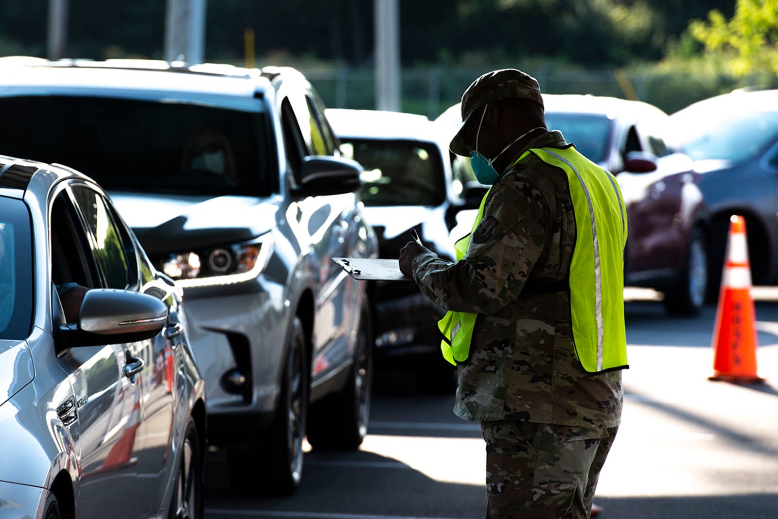 Chief Master Sgt. Daniel McCain, 88th Medical Group superintendent, writes down a patient’s information while volunteering in the drive through line of the Kittyhawk Pharmacy Aug. 7. (U.S. Air Force photo/Wesley Farnsworth)