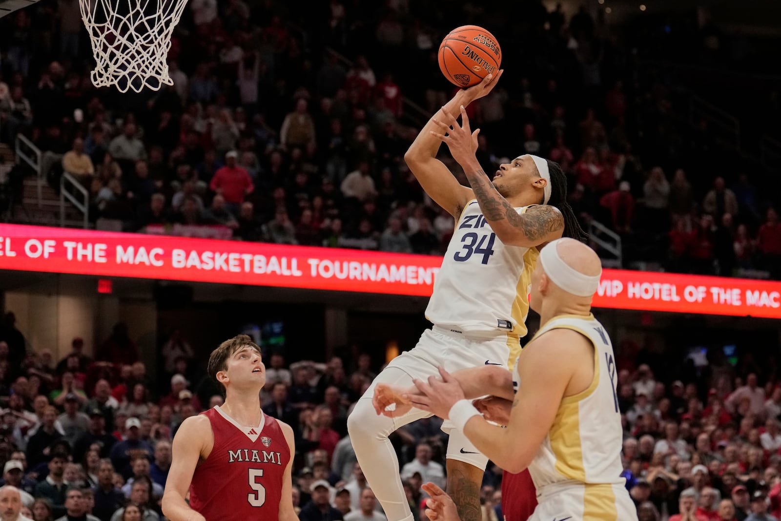 Akron guard Nate Johnson, center, shoots the game winning basket in front of Miami (Ohio) guard Peter Suder, left, in the second half of an NCAA college basketball game in the championship of the Mid-American Conference tournament, Saturday, March 15, 2025, in Cleveland, Ohio. (AP Photo/Sue Ogrocki)