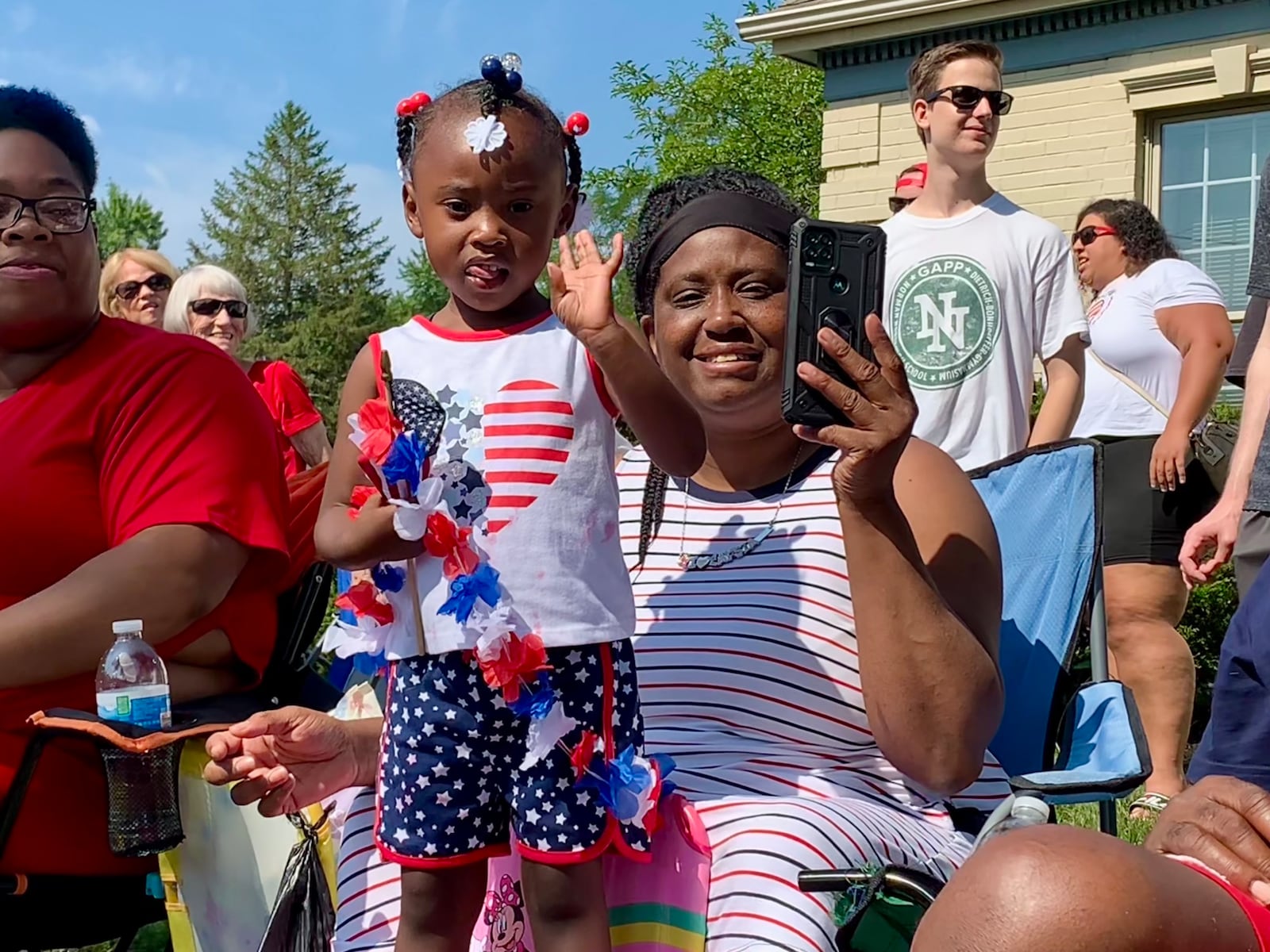 Three-year-old Mi'laysia Thomas waves to paradegoers during the Americana Festival in Centerville, July 4, 2023. LONDON BISHOP/STAFF