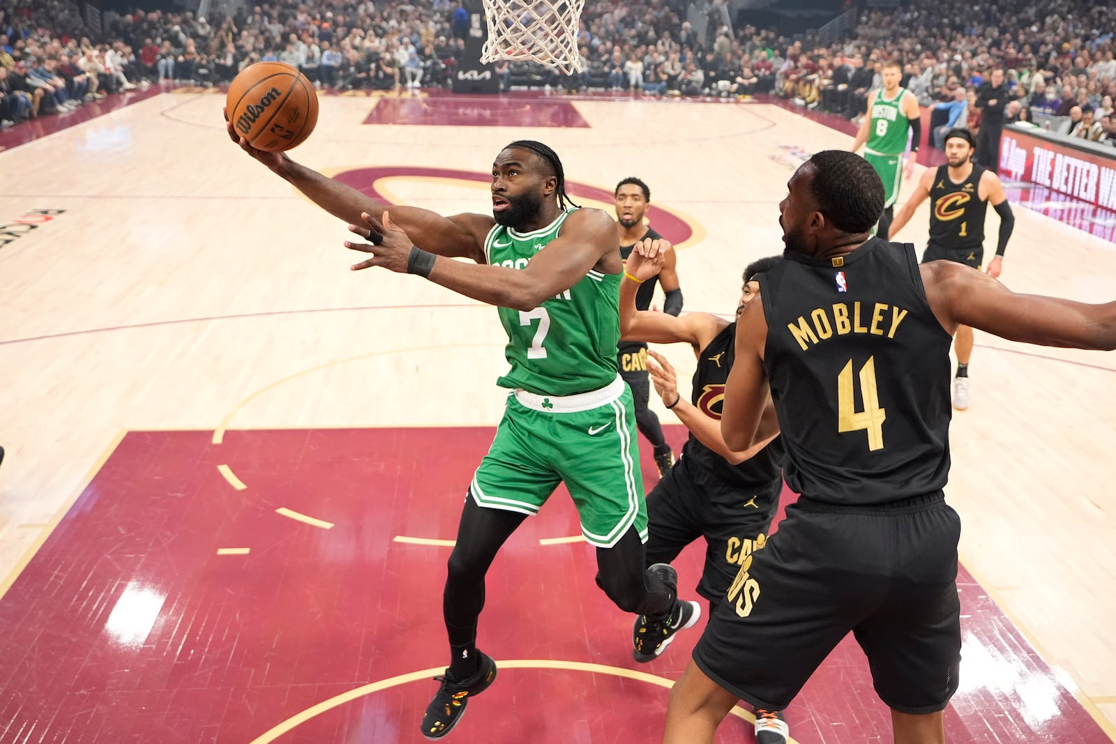 Boston Celtics guard Jaylen Brown (7) shoots in front of Cleveland Cavaliers forward Evan Mobley (4) in the first half of an NBA basketball game, Tuesday, Feb. 4, 2025, in Cleveland. (AP Photo/Sue Ogrocki)