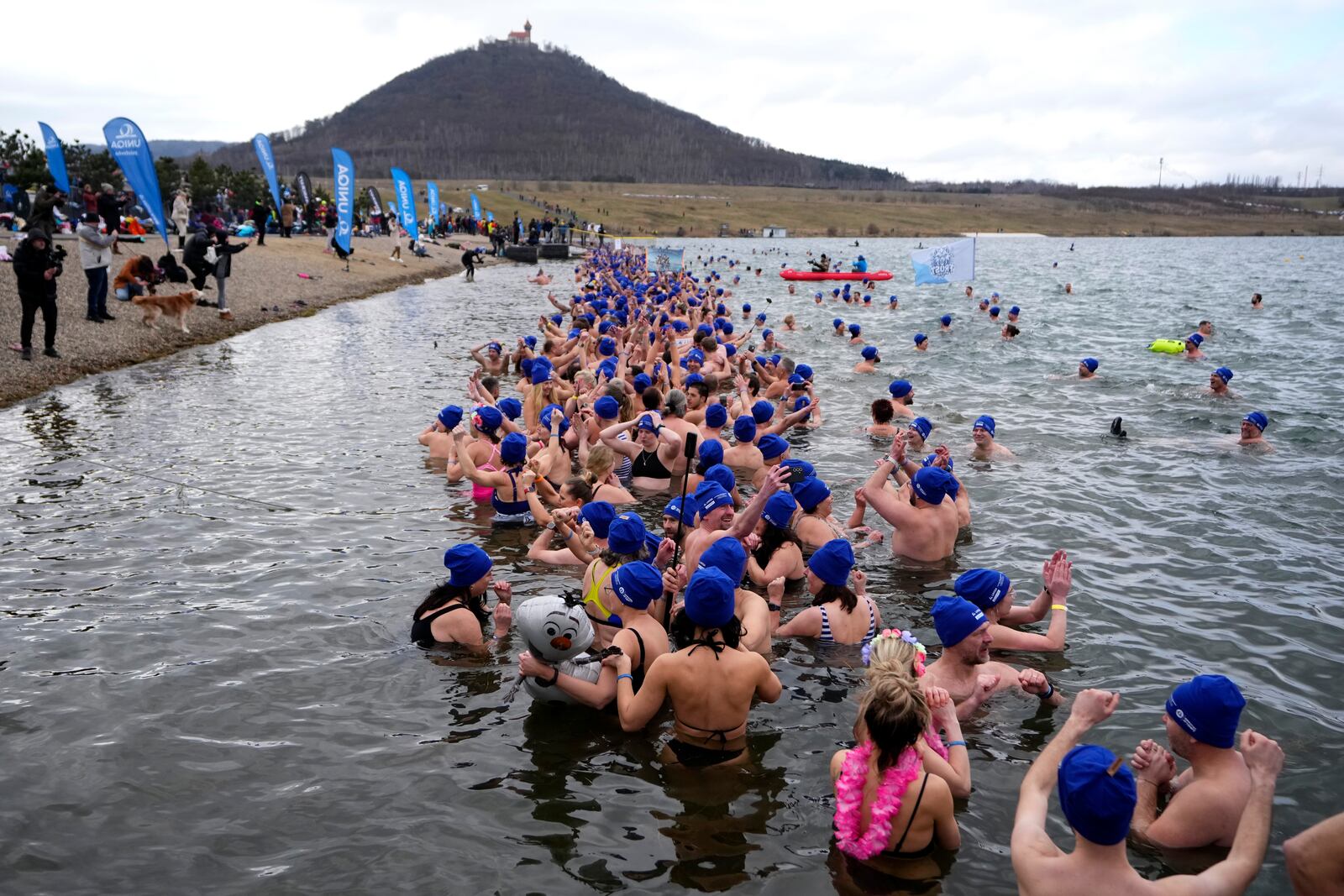 Some of 2461 polar swimmers wait in the water to set a world record for the largest polar bear dip at a lake in Most, Czech Republic, Saturday, March 1, 2025. (AP Photo/Petr David Josek)