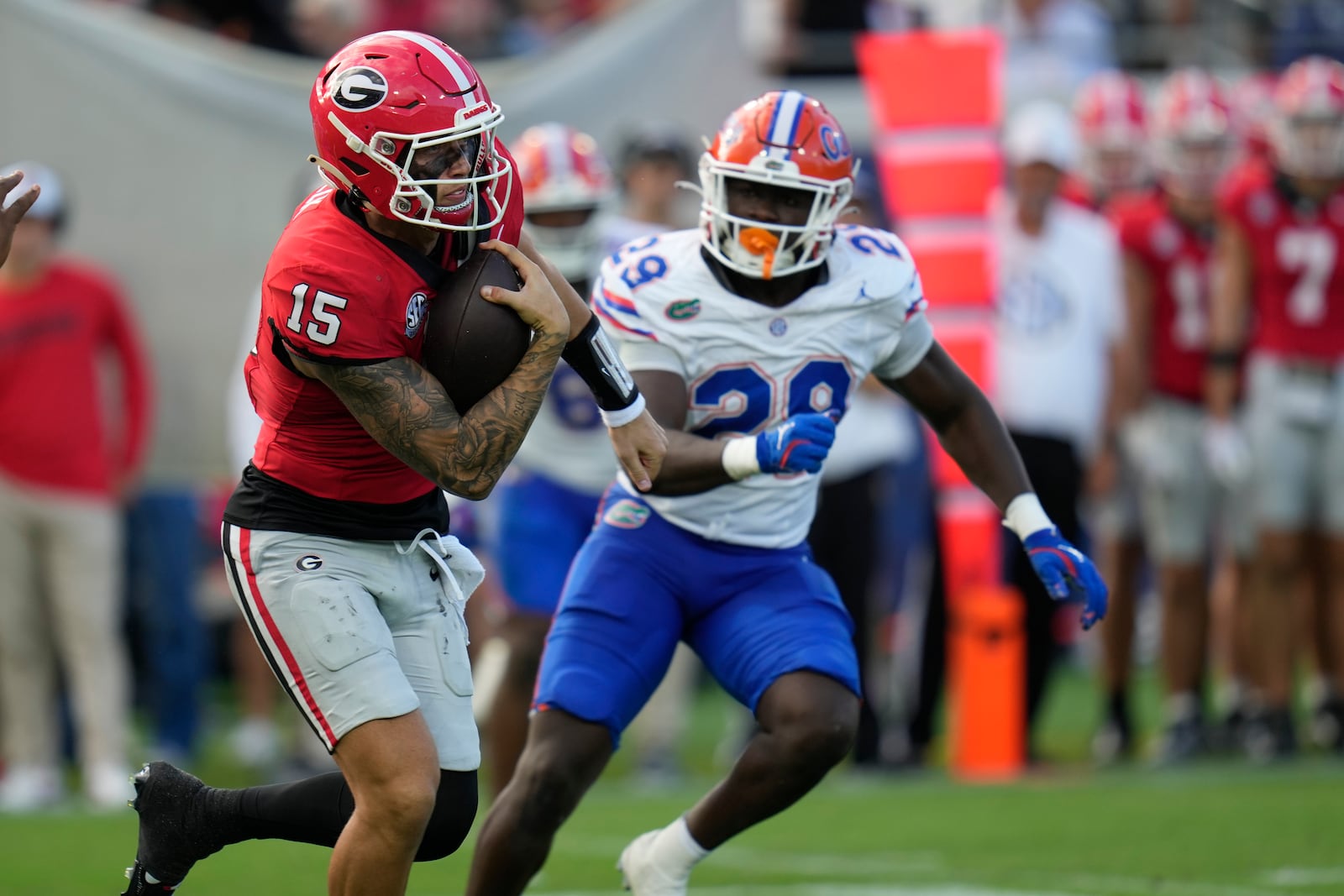 Georgia quarterback Carson Beck (15) runs for yardage against Florida defensive back Devin Moore (28) during the first half of an NCAA college football game, Saturday, Nov. 2, 2024, in Jacksonville, Fla. (AP Photo/John Raoux)