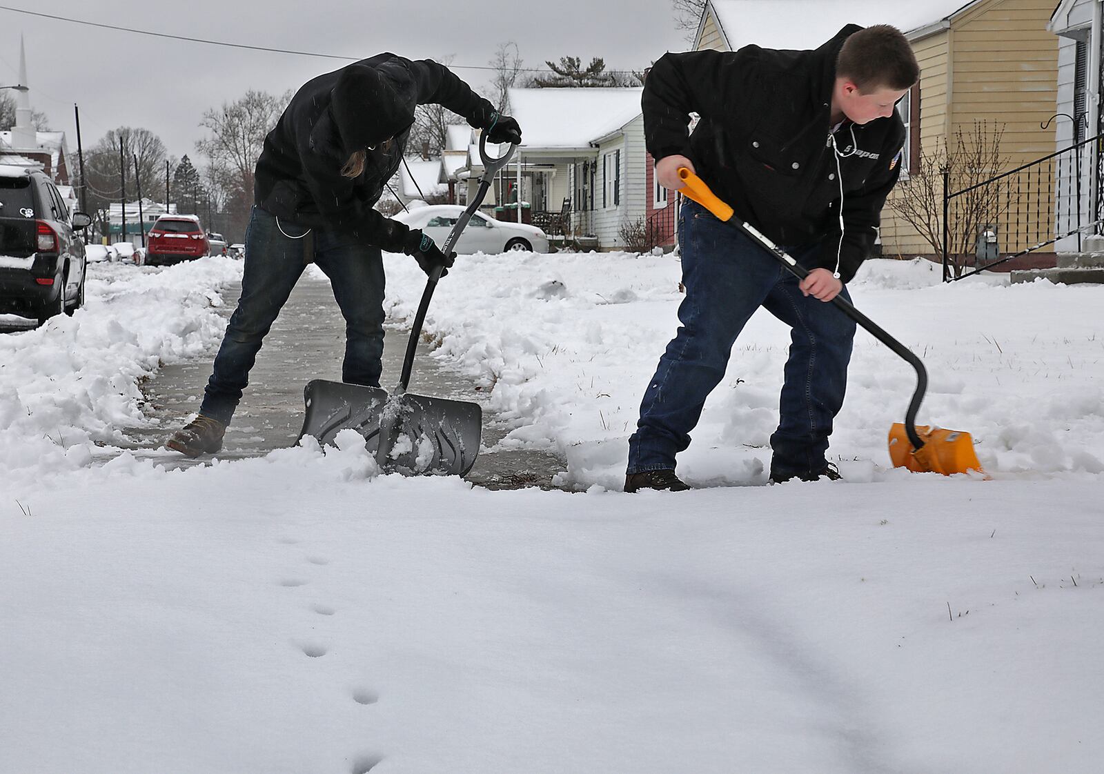 Jacob Richard, left, and Hayden Ford shovel sidewalks along Hillside Avenue in Springfield Sunday. BILL LACKEY/STAFF