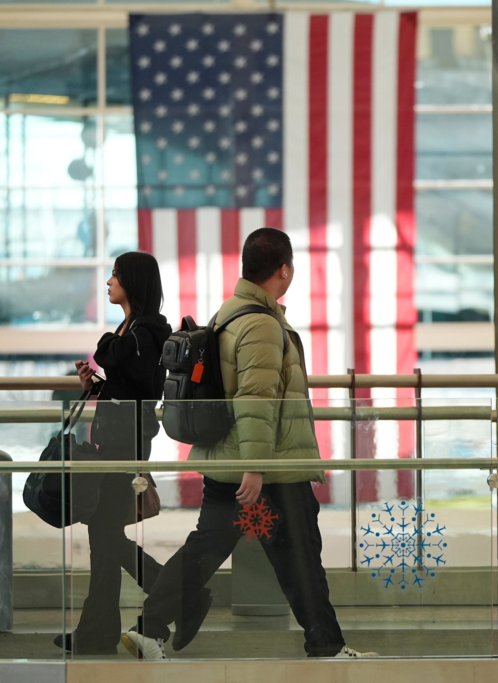 Travellers pass the main terminal of Denver International Airport Tuesday, Dec. 24, 2024, in Denver. (AP Photo/David Zalubowski)