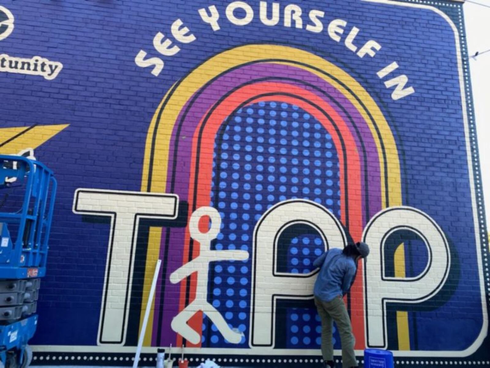 Here's a look at the painting process of the new "See Yourself in Tipp" mural on the wall of the Tipp City Public Library facing the Coldwater Café at their shared outdoor patio space in October 2020. PHOTO COURTESY OF THE TIPP CITY PUBLIC LIBRARY