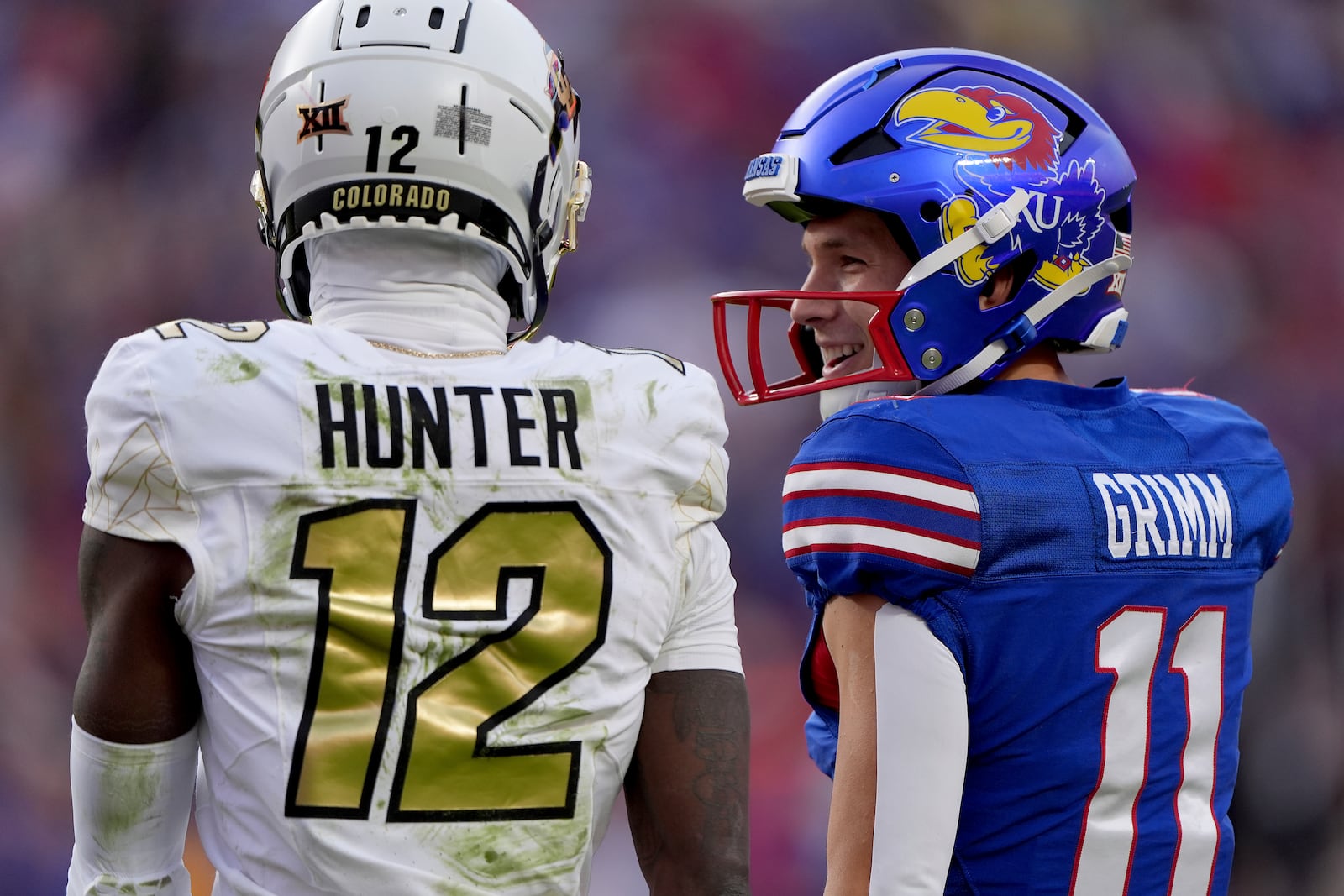 Kansas wide receiver Luke Grimm (11) and Colorado corner back Travis Hunter (12) talk between plays during the first half of an NCAA college football game, Saturday, Nov. 23, 2024, in Kansas City, Mo. (AP Photo/Charlie Riedel)