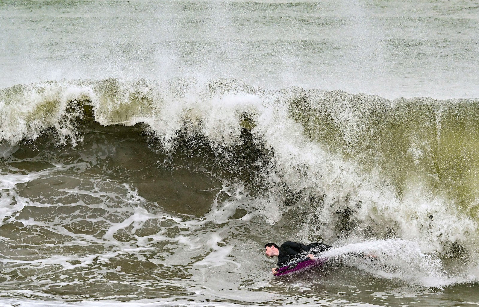 Surfers take to the water as big waves hit the shore in Seal Beach, Calif., Monday, Dec. 23, 2024. (Jeff Gritchen/The Orange County Register via AP)