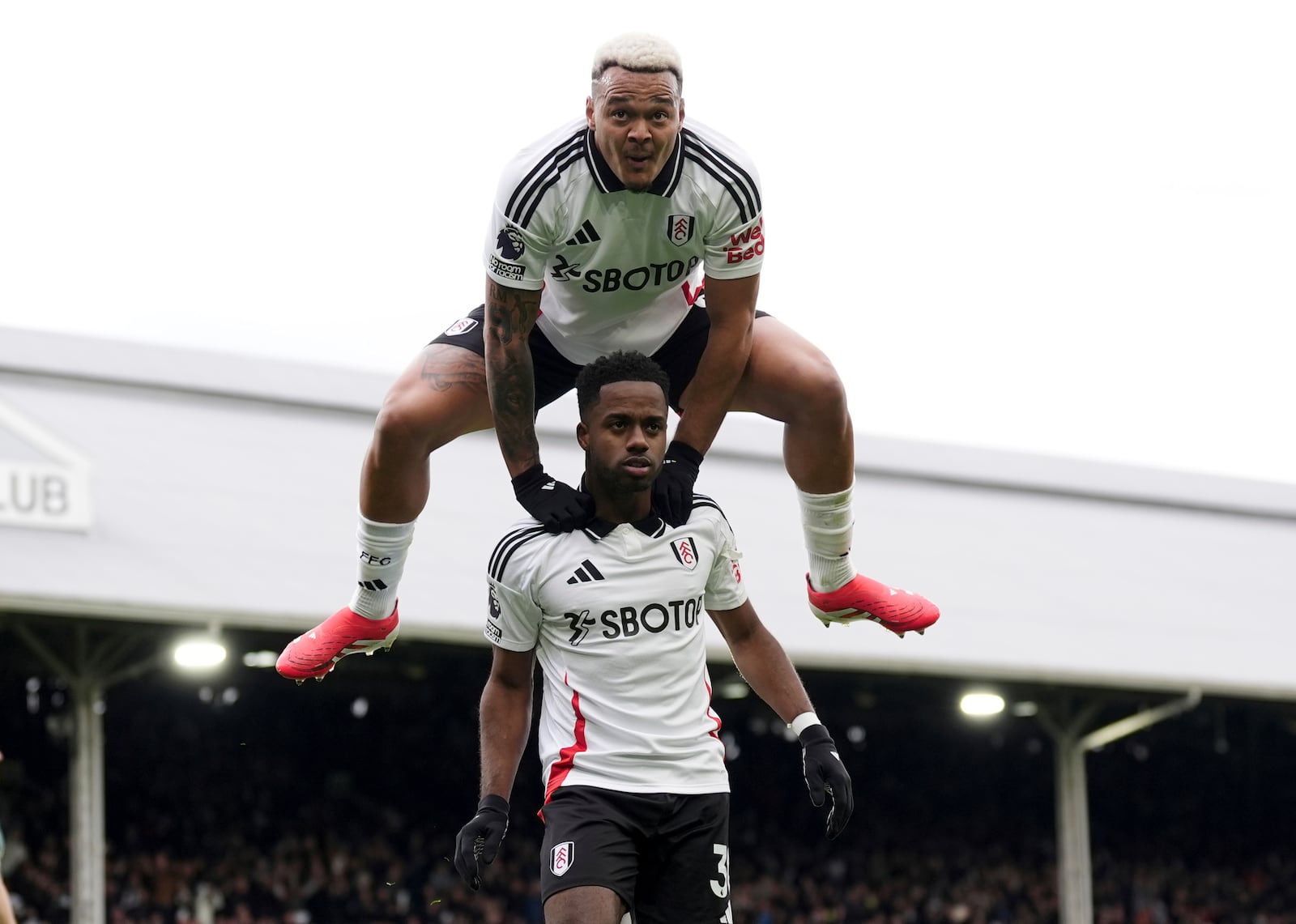 Fulham's Ryan Sessegnon, bottom, celebrates after scoring his side's second goal with Rodrigo Muniz during the English Premier League soccer match between FC Fulham and Tottenham Hotspur, in London, Sunday, March 16, 2025. (Zac Goodwin/PA via AP)