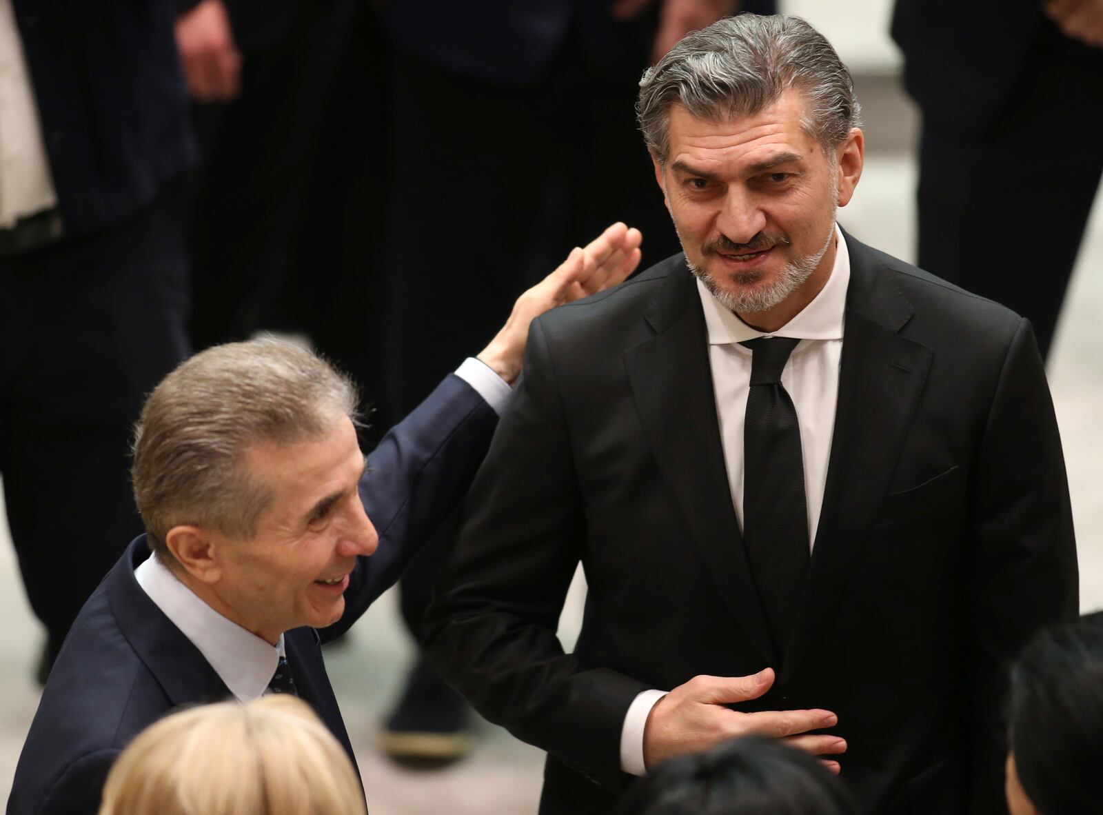 Georgian Dream party founder Bidzina Ivanishvili, left, embraces Georgian President-elect Mikheil Kavelashvili at his swearing-in ceremony at the Georgian Parliament in Tbilisi, Georgia, Sunday, Dec. 29, 2024. (Irakli Gedenidze/Pool Photo via AP)