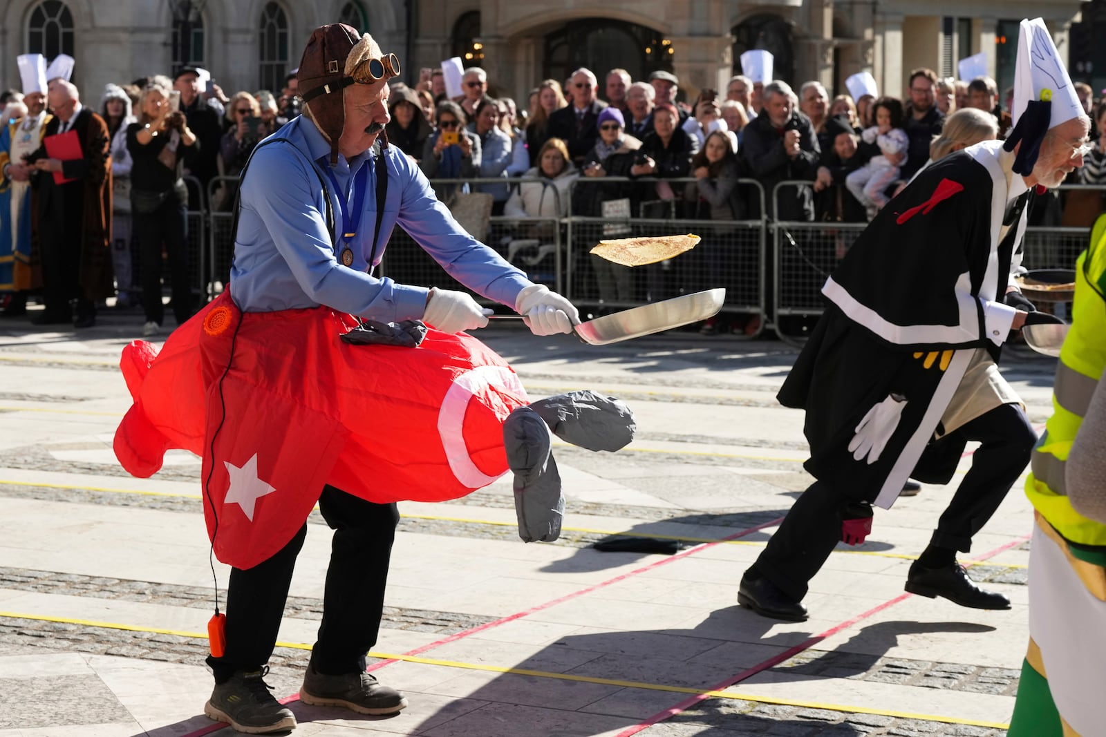 Runners in costumes compete during a traditional pancake race by livery companies at the Guildhall in London, Tuesday, March 4, 2025.(AP Photo/Frank Augstein)