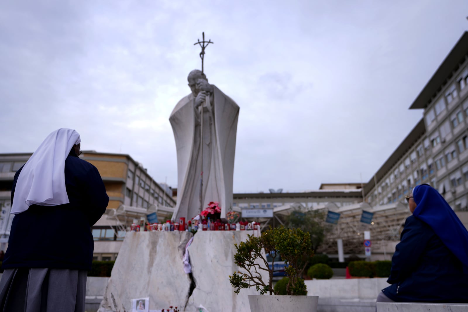 People pray for Pope Francis in front of the Agostino Gemelli Polyclinic, where the Pontiff has been hospitalized since Feb. 14, in Rome, Wednesday, Feb. 26, 2025. (AP Photo/Kirsty Wigglesworth)