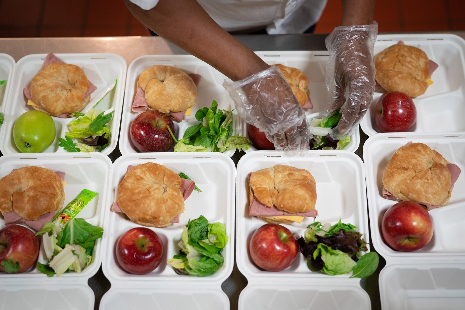 FILE — A cafeteria worker prepares lunches at an elementary school in Baltimore, April 14, 2020. Interventions like expanding physical activity and nutrition programs in schools have not been enough to prevent weight gain and obesity in children and adolescents, scientists say. (Erin Schaff/The New York Times)