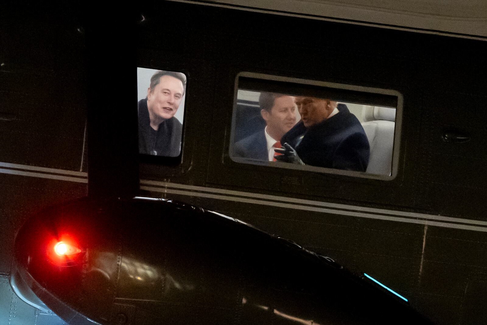 Elon Musk, left, and President Donald Trump, right, are seen through the windows as Marine One lands on the South Lawn of the White House, Wednesday, Feb. 19, 2025, in Washington. (AP Photo/Alex Brandon)