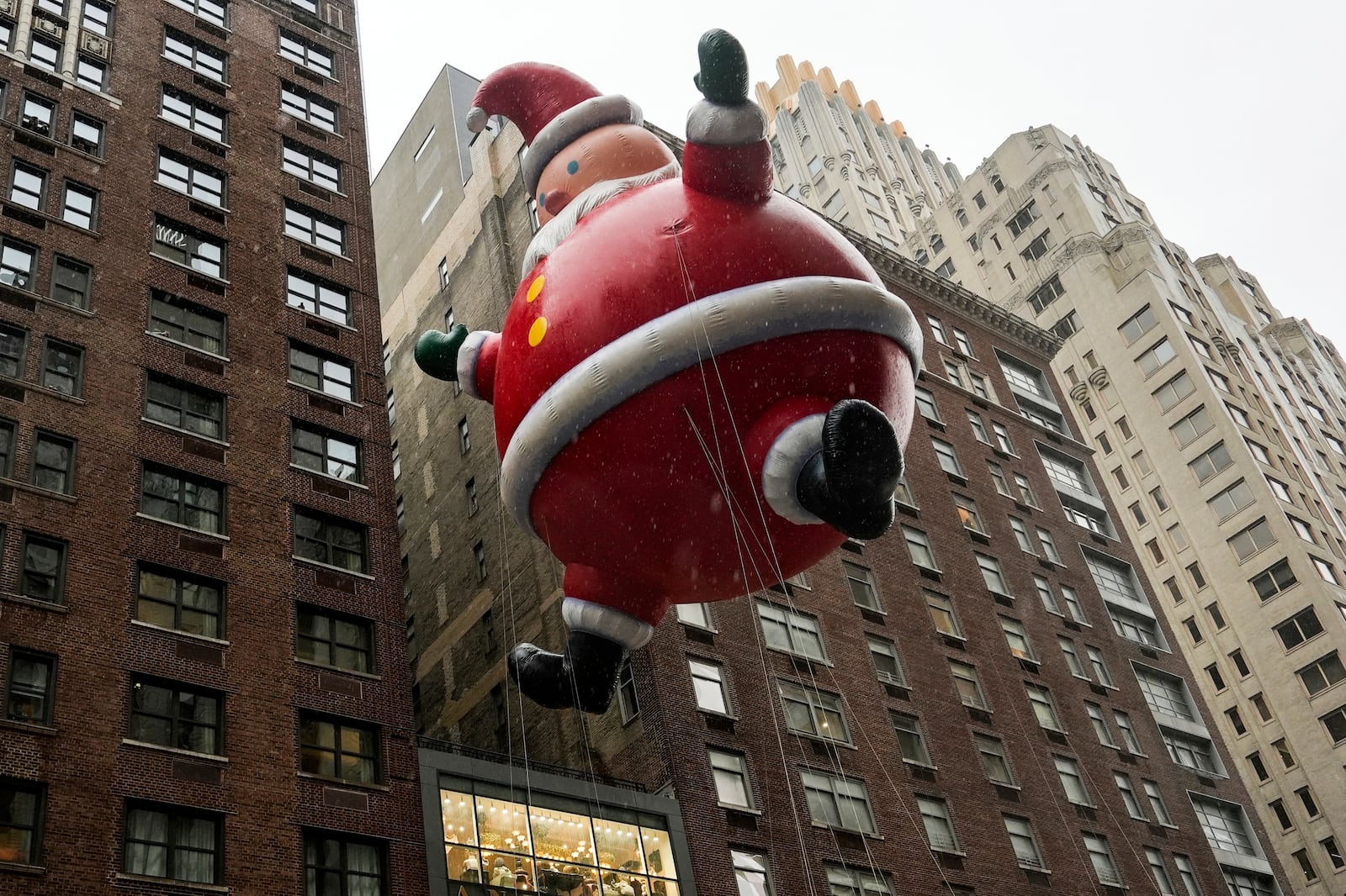 FILE - Handlers guide a Santa Claus balloon down Sixth Avenue during the Macy's Thanksgiving Day Parade, Thursday, Nov. 28, 2024, in New York. (AP Photo/Julia Demaree Nikhinson, File)