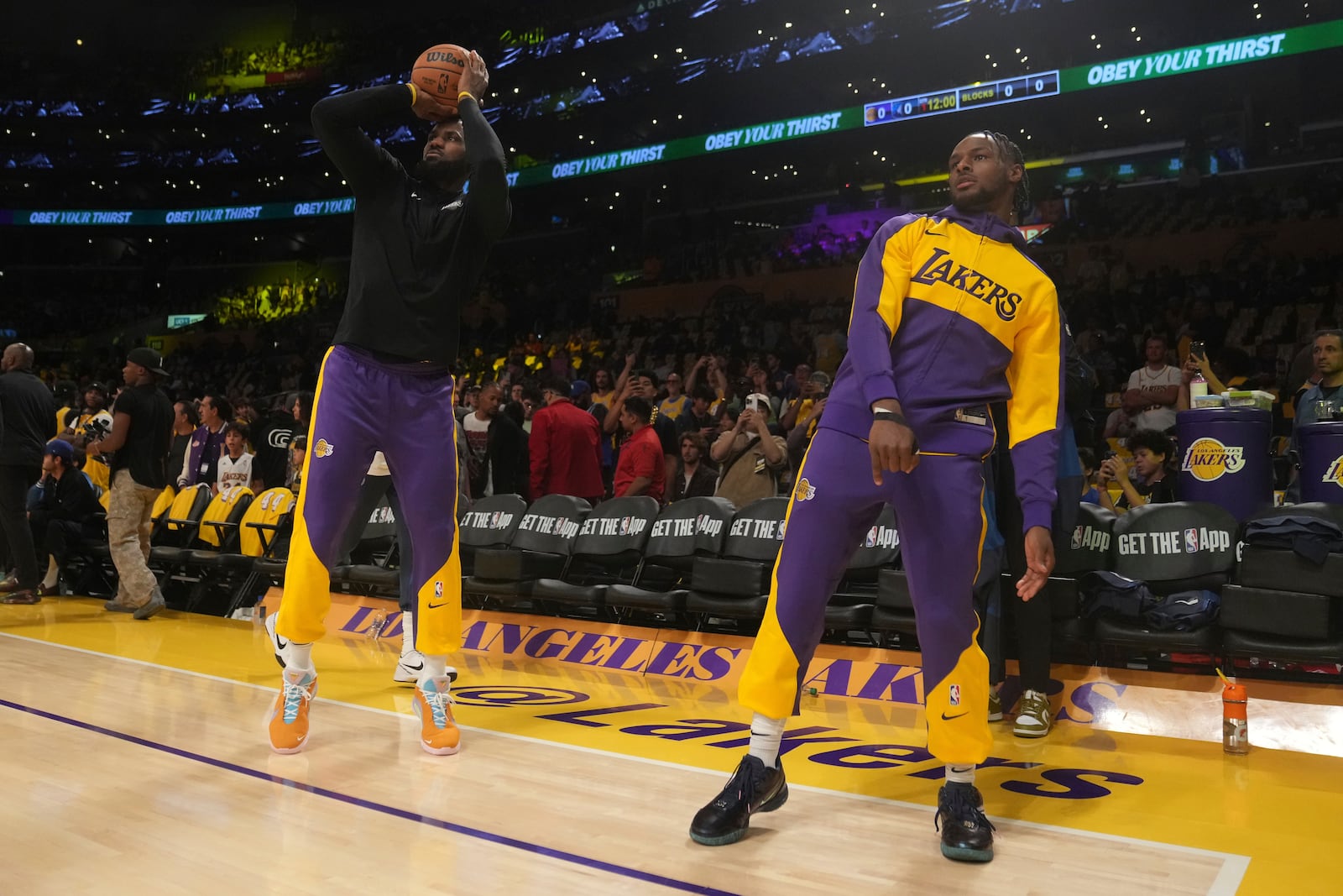 Los Angeles Lakers forward LeBron James, left, and guard Bronny James warm up before an NBA basketball game against the Minnesota Timberwolves, Tuesday, Oct. 22, 2024, in Los Angeles. (AP Photo/Eric Thayer)