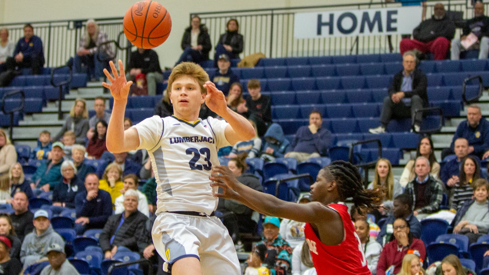 Oakwood's Will Maxwell passes over Northridge's Taron Hill during Friday night's Division II tournament game at Trent Arena. Oakwood advanced with a 59-39 victory. CONTRIBUTED/Jeff Gilbert