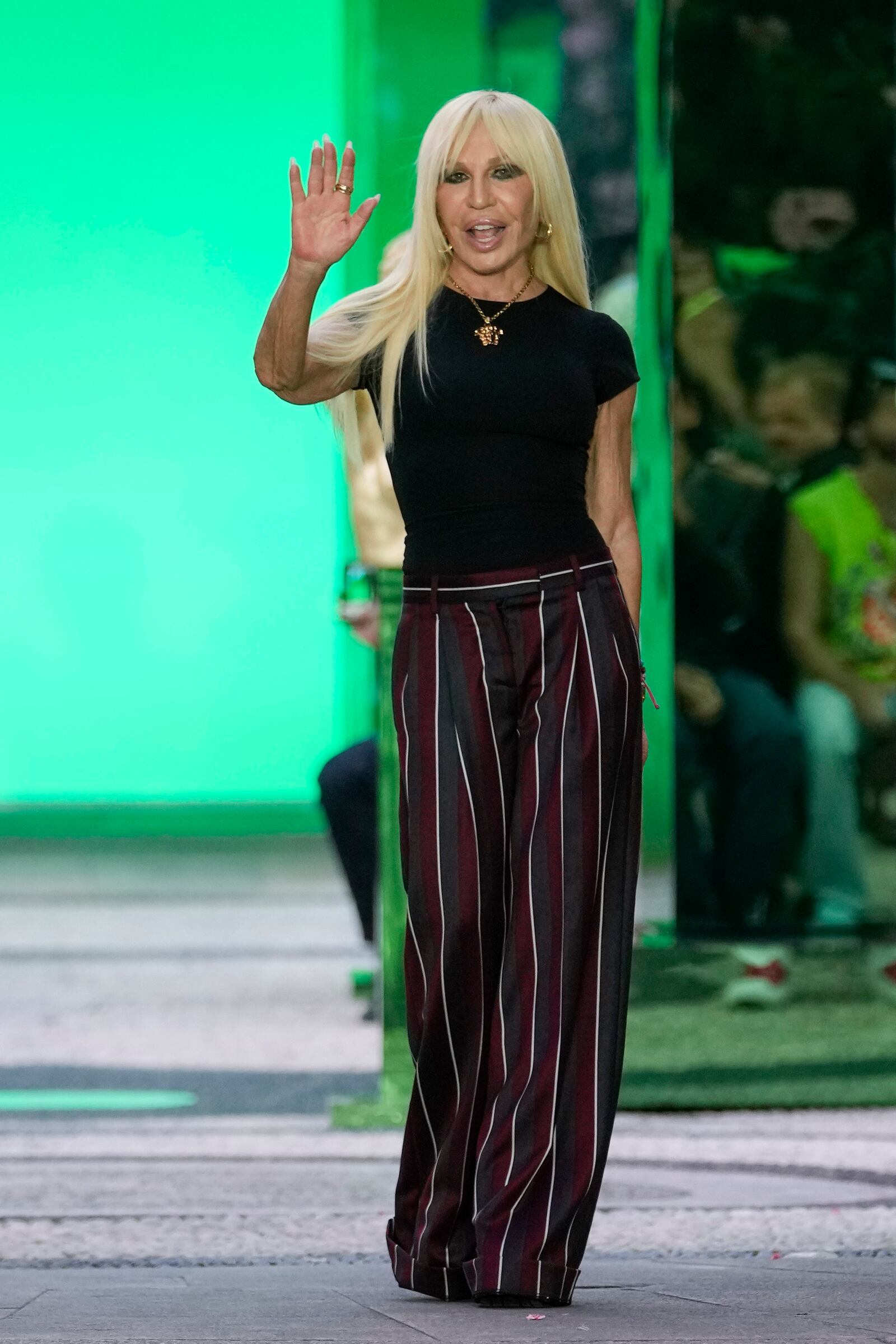 FILE - Designer Donatella Versace accepts applause at the end of the Versace men's Spring Summer 2023 collection presented in Milan, Italy, Saturday, June 18, 2022. (AP Photo/Luca Bruno, File)