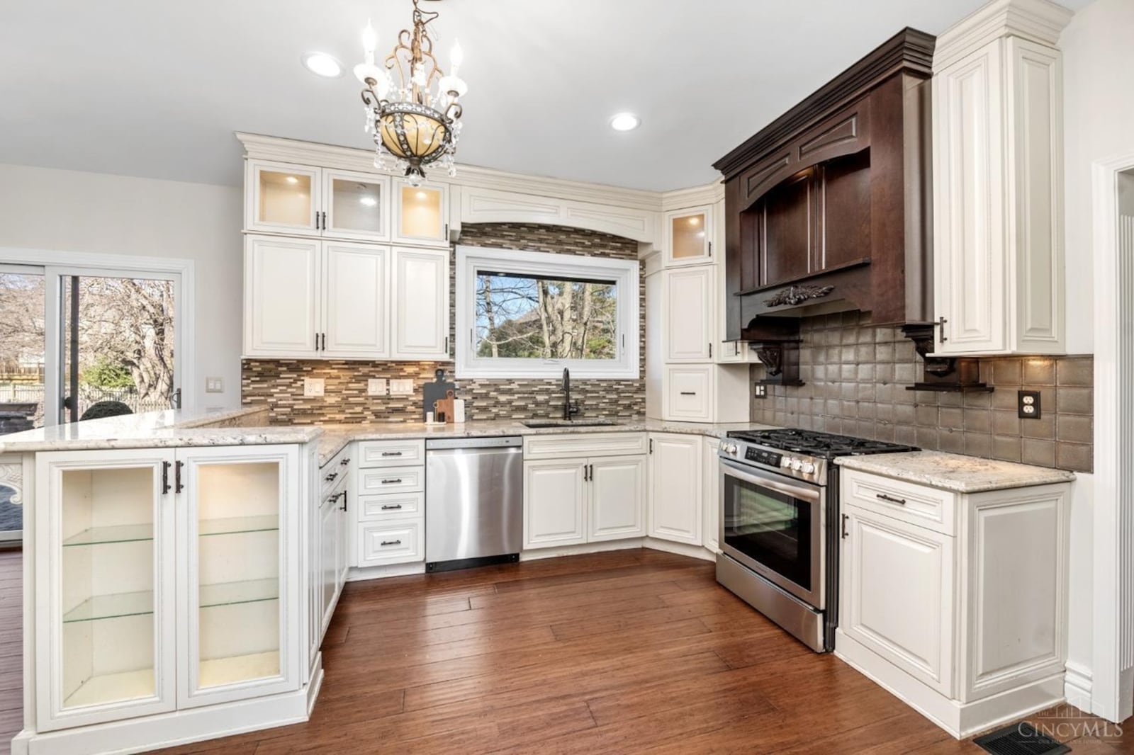 The kitchen has been updated and has stainless appliances, white cabinets and marble countertops and hardwood flooring.