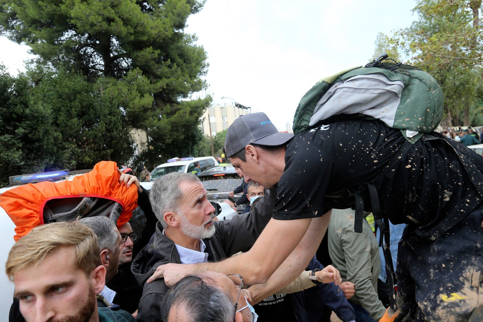 Spain's King Felipe VI listens to a person affected by the floods after a crowd of angry survivors of Spain's floods tossed mud and shouted insults at the King and government officials when they made their first visit to one of the hardest hit towns after floods in Paiporta near Valencia, Spain, Sunday, Nov. 3, 2024. (AP Photo/Hugo Torres)