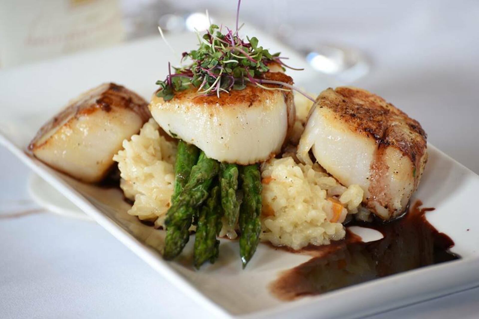 Scallops with butternut squash risotto, fried leeks, balsamic reduction and brown butter, on the menu at Coldwater Cafe & Catering. Photo from Coldwater Cafe Facebook page