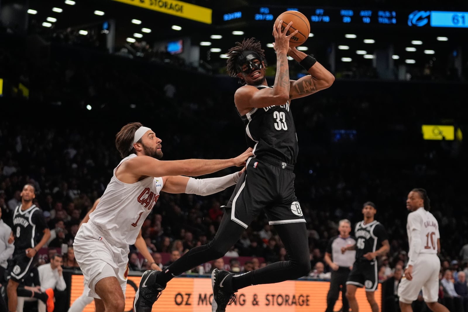 Cleveland Cavaliers' Max Strus (1) defends Brooklyn Nets' Nic Claxton (33) during the second half of an NBA basketball game Thursday, Feb. 20, 2025, in New York. (AP Photo/Frank Franklin II)