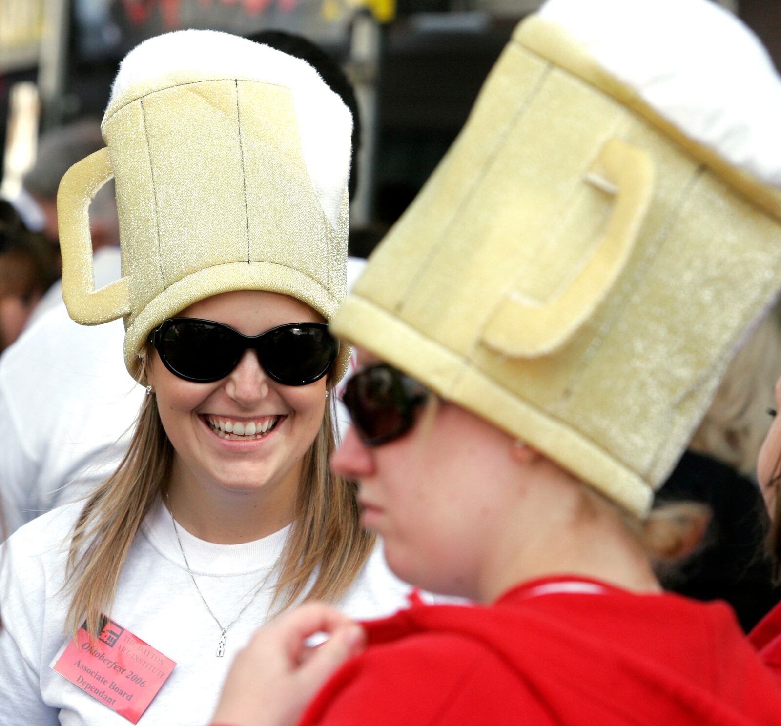 Volunteers Aleena Rorapaugh, left, and Mary Beth Lintz wore beer mug hats to attact attention to their photo business at the Dayton Art Insitute's Oktoberfest.