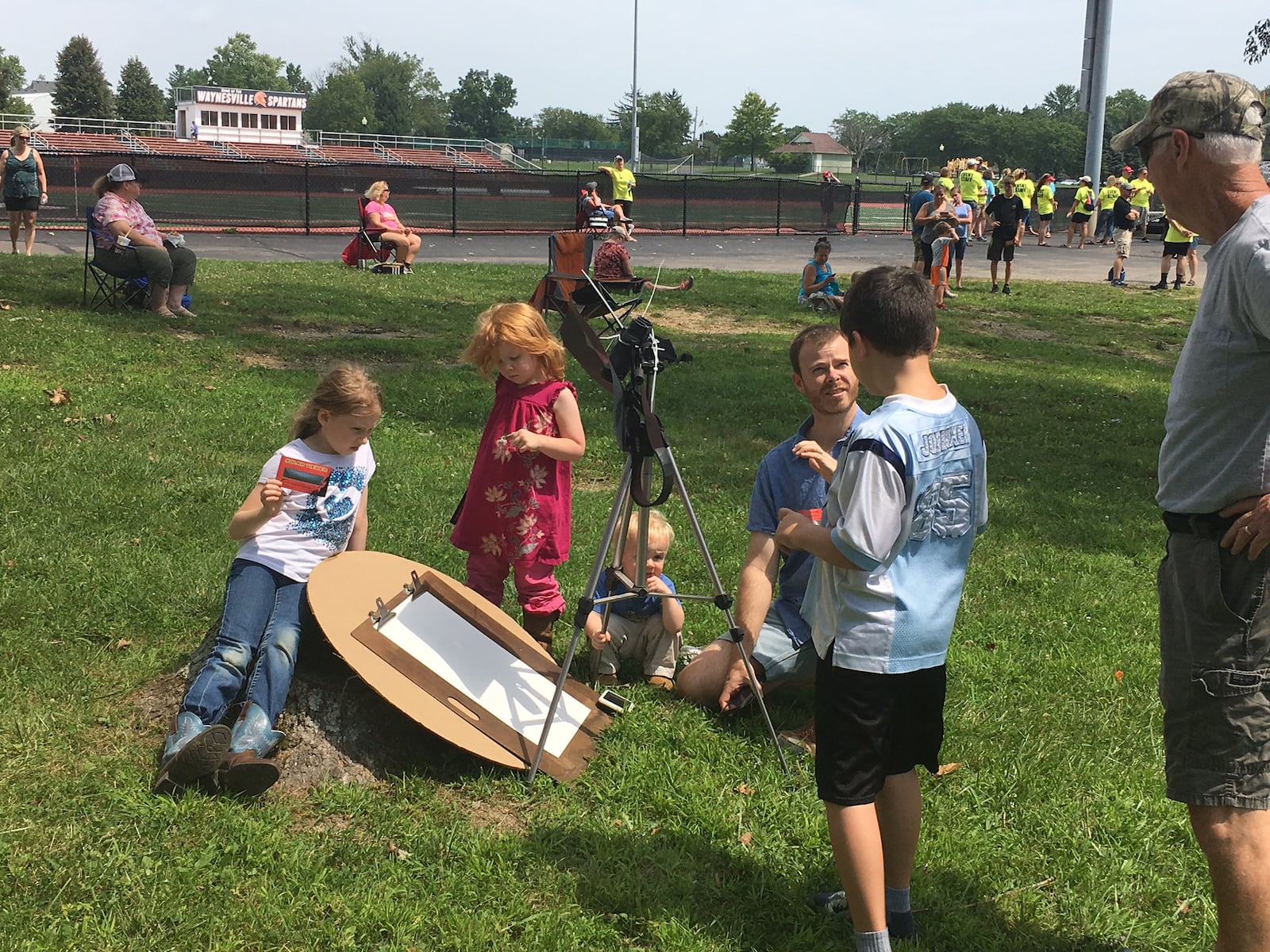 Dozens of people gathered next to Waynesville schools’ stadium to watch the partial solar eclipse on Monday, Aug. 21, 2017. JEREMY KELLEY / STAFF