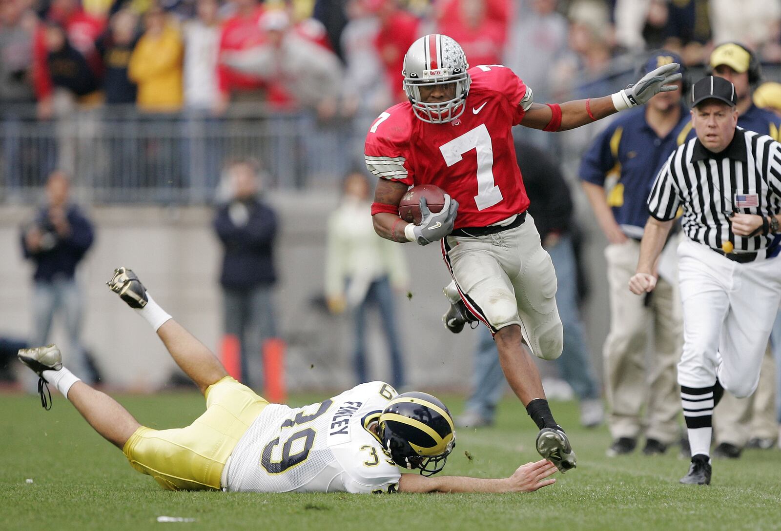 COLUMBUS, OH - NOVEMBER 20:  Defensive back Ted Ginn Jr. #7 of the Ohio State Buckeyes runs around punter Adam Finley #39 of the Michigan Wolverines for an 82-yard touchdown return during the third quarter on November 20, 2004 at Ohio Stadium in Columbus, Ohio.  Ohio State upset Michigan 37-21.  (Photo by Brian Bahr/Getty Images)