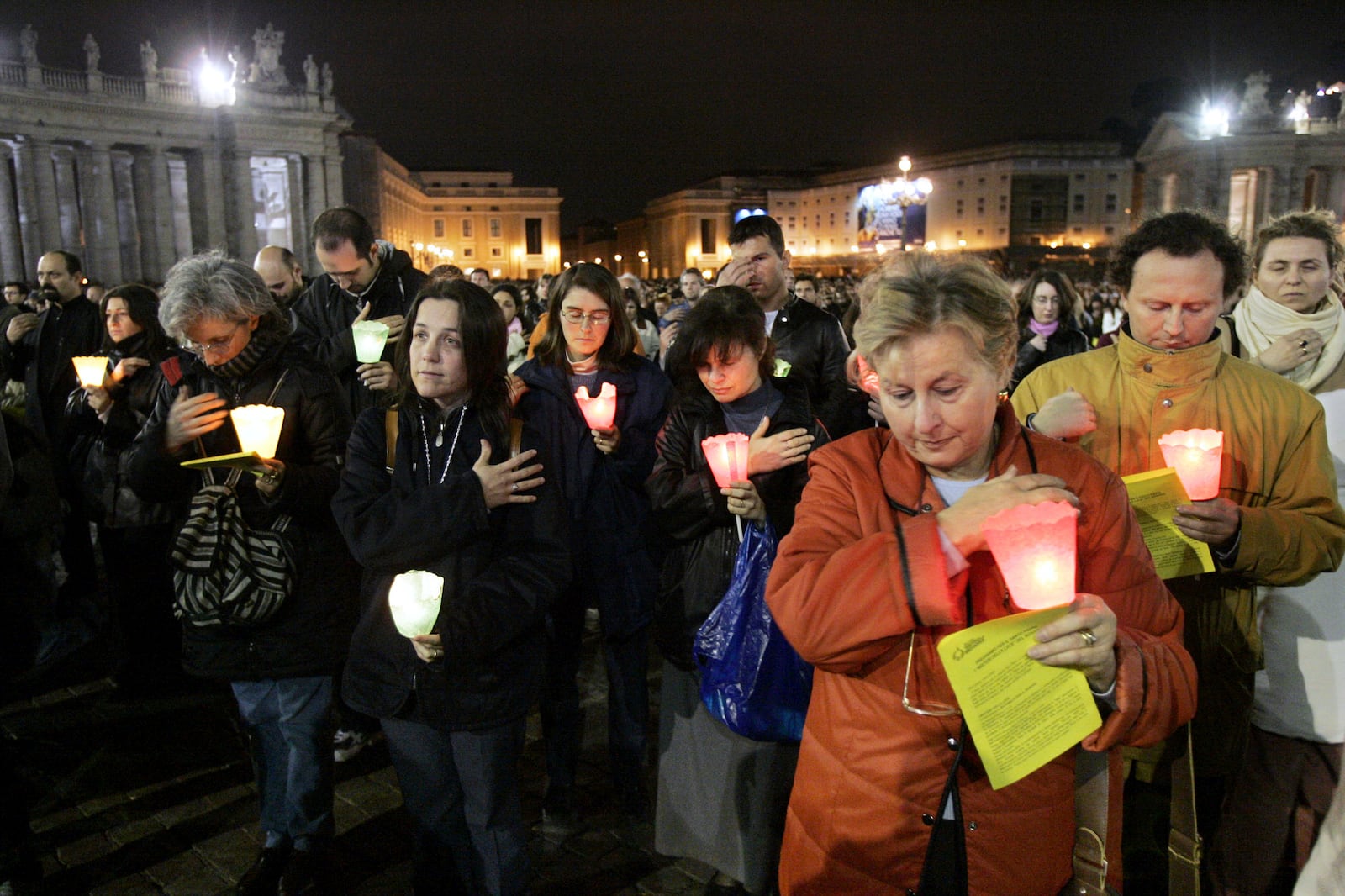 FILE - Faithful make the sign of the cross during a rosary vigil prayer for Pope John Paul II's health in St. Peter's Square at The Vatican, Friday, April 1, 2005. (AP Photo/Luca Bruno, file)