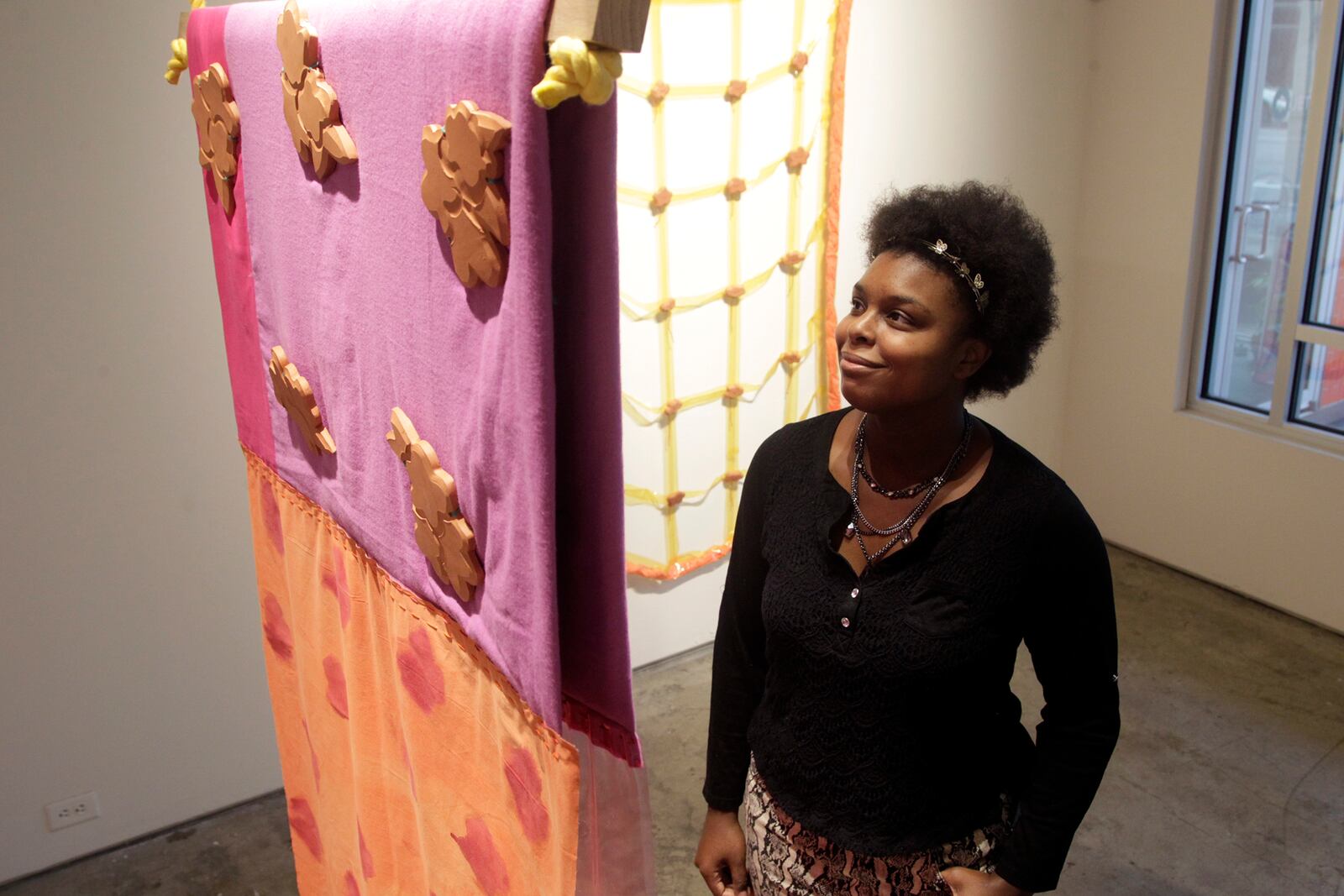 Cydnie King, executive assistant at The Contemporary Dayton, looks at artworks by artist Britny Wainwright, part of the exhibition, Matter and Pattern. The show was the second in the Still SHE Creates series of exhibitions that highlight women artists pushing boundaries in contemporary art. LISA POWELL / STAFF