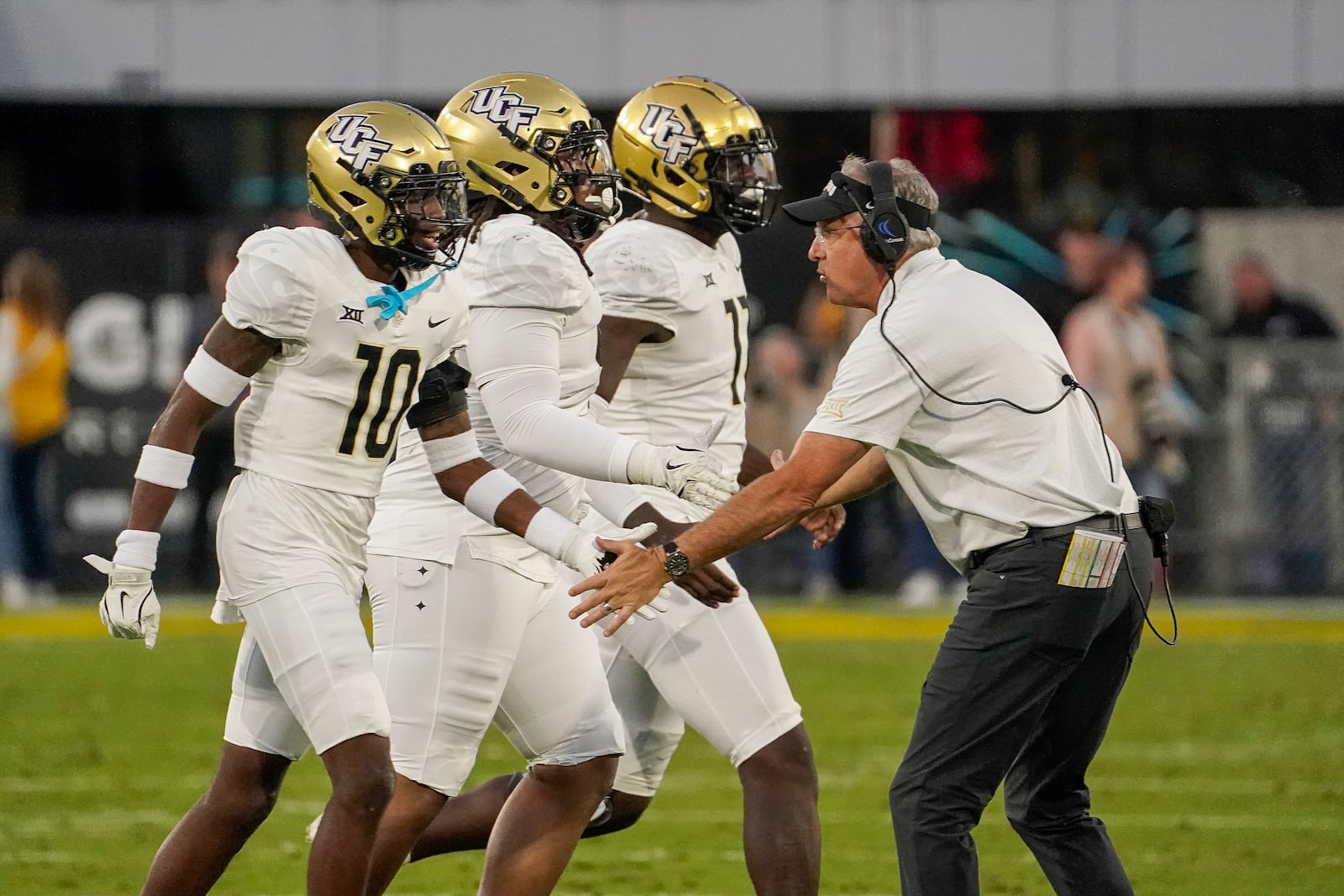 Central Florida head coach Guz Malzahn, right, congratulates his defense after stopping Arizona State on a fourth down conversion attempt during the first half of an NCAA college football game Saturday, Nov. 9, 2024, in Tempe, Ariz. (AP Photo/Darryl Webb)