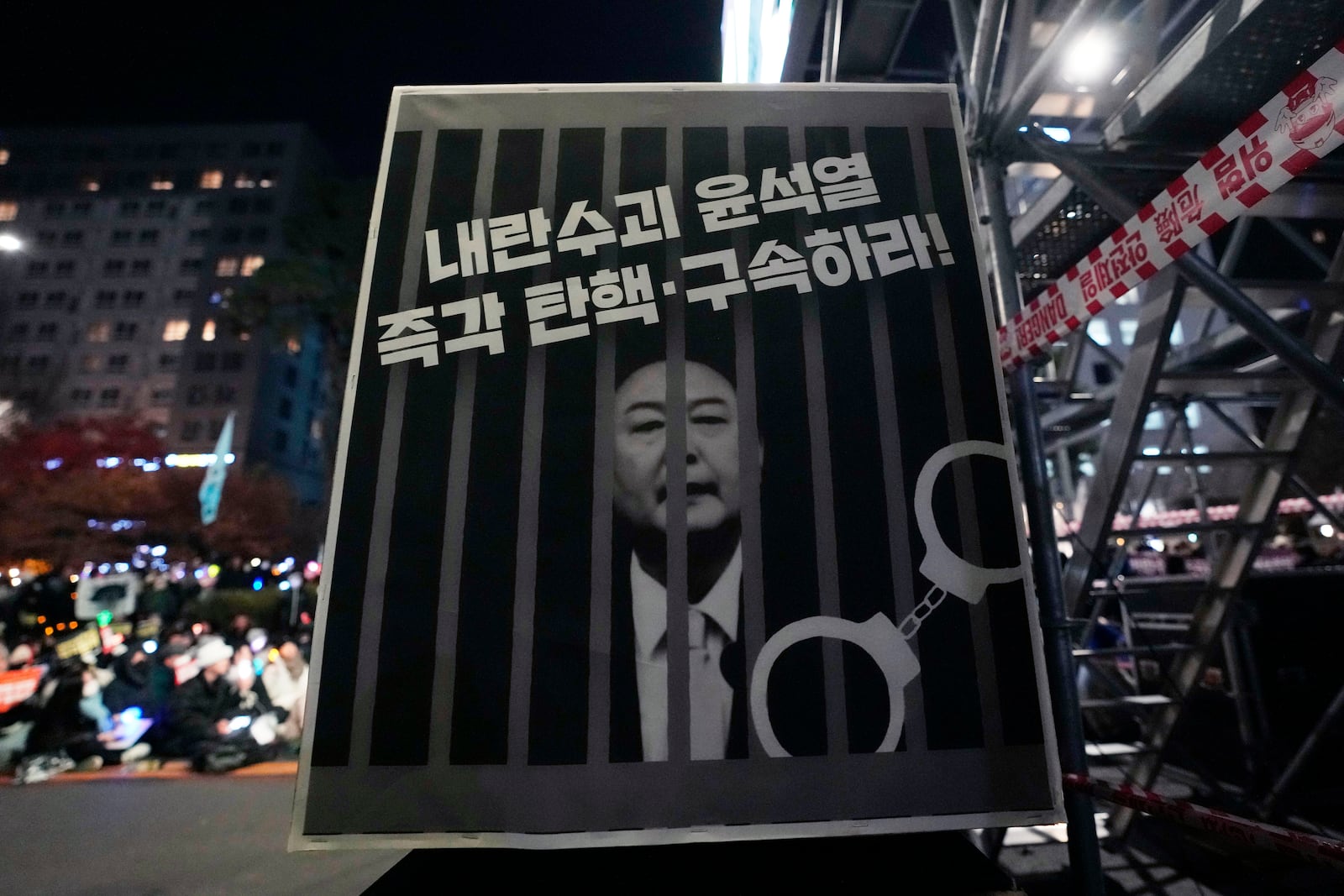 An image of depicting an imprisoned South Korean President Yoon Suk Yeol is displayed during a rally to demand his impeachment outside the National Assembly in Seoul, South Korea, Friday, Dec. 13, 2024. The signs read "Arrest and impeach the rebellion leader Yoon Suk Yeol." (AP Photo/Ahn Young-joon)