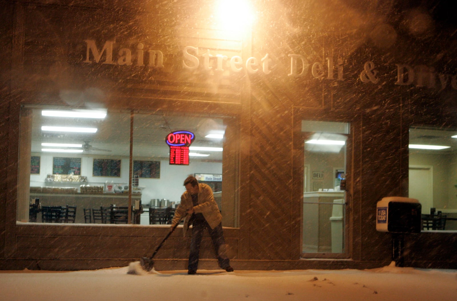 In this file photo f rom 2009, Steve Swank, owner of the Main Street Deli in Springboro, cleans the sidewalk in front of his business as he prepares for the workday. The deli announced on Facebook it will shut its doors on Jan. 30, 2021.