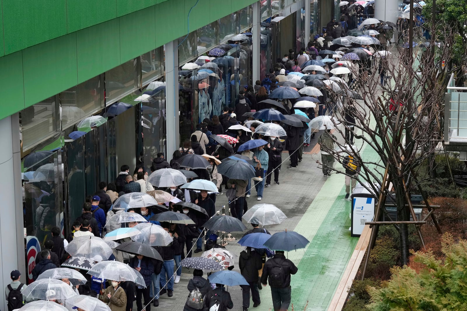 Baseball fans wait in line to get into an MLB souvenir store before the Tokyo Series exhibition games with the Los Angeles Dodgers, the Chicago Cubs, the Yomiuri Giants and the Hanshin Tigers at Tokyo Dome in Tokyo, Sunday, March 16, 2025. (AP Photo/Hiro Komae)