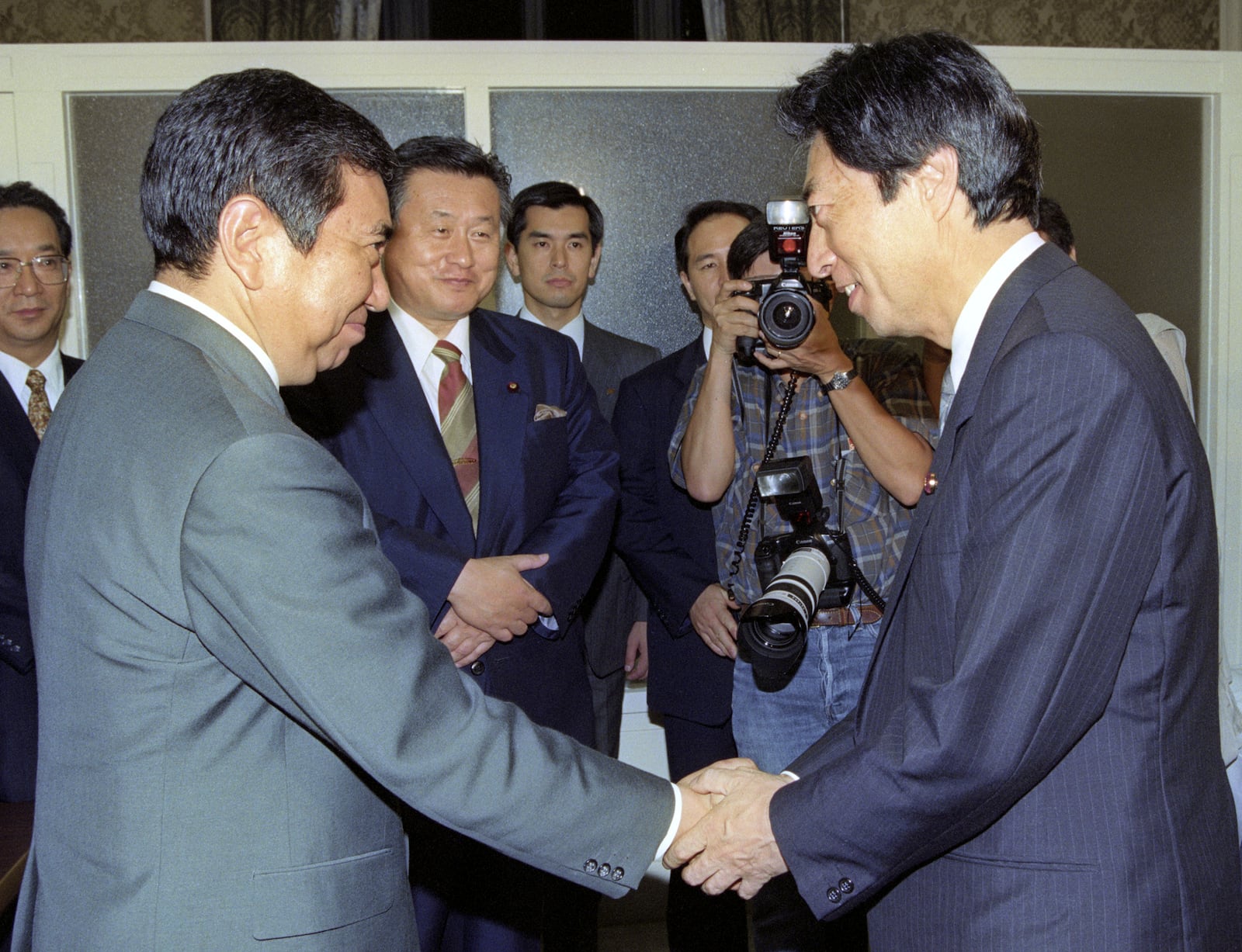 Japan's newly appointed Prime Minister Morihiro Hosokawa, right, greets the Liberal Democratic Party's President Yohei Kono, left, at the parliament in Tokyo, on Aug. 6, 1993. (Kyodo News via AP)