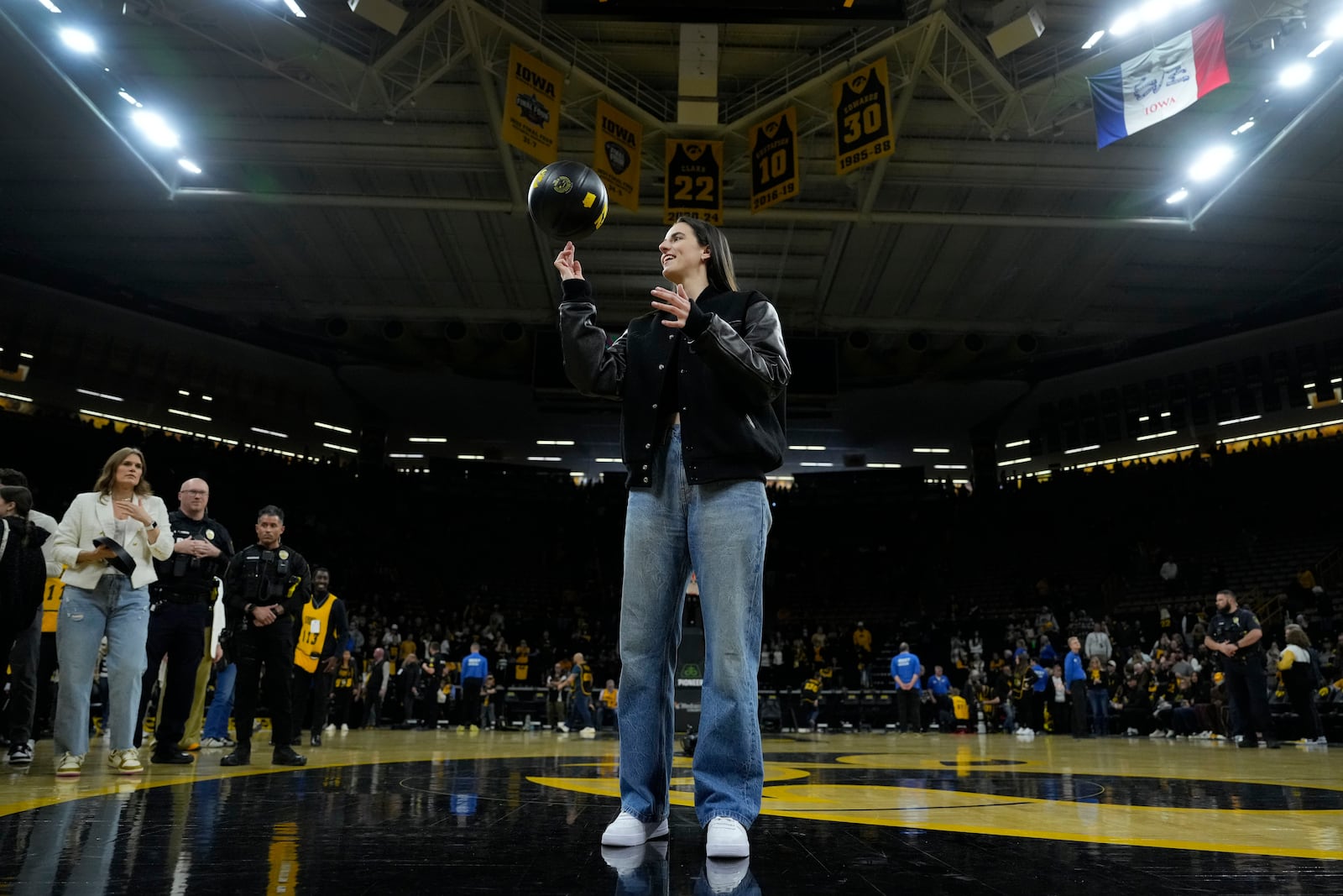 Former Iowa guard and current Indiana Fever WNBA player Caitlin Clark stands on the court during her jersey retirement ceremony after an NCAA college basketball game between Iowa and Southern California, Sunday, Feb. 2, 2025, in Iowa City, Iowa. (AP Photo/Charlie Neibergall)