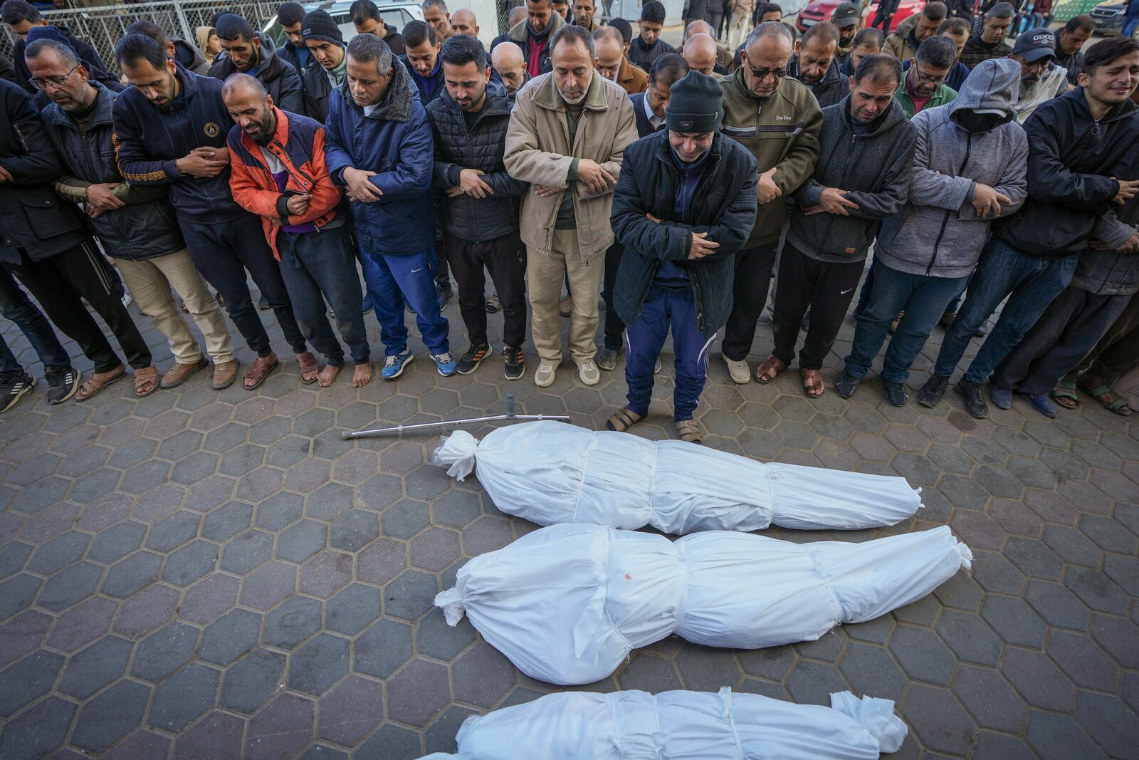 Mourners pray over the bodies of 5-year-old Dima Eid, her uncle, and her grandfather, who were killed in an Israeli airstrike on Saturday, during their funeral in Deir al-Balah, central Gaza Strip, Sunday, Jan. 12, 2025. (AP Photo/Abdel Kareem Hana)