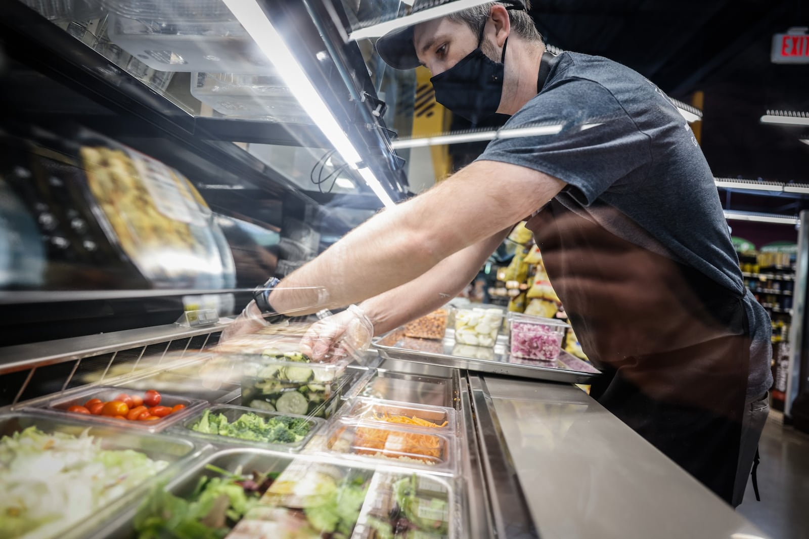 Gem City Market Deli Manager, Chris Bender, puts together lunch salad bar at the market on Tuesday May 10. 2022. This Saturday May 14, Gem City Market will hold a celebration of it's first year anniversary. JIM NOELKER/STAFF